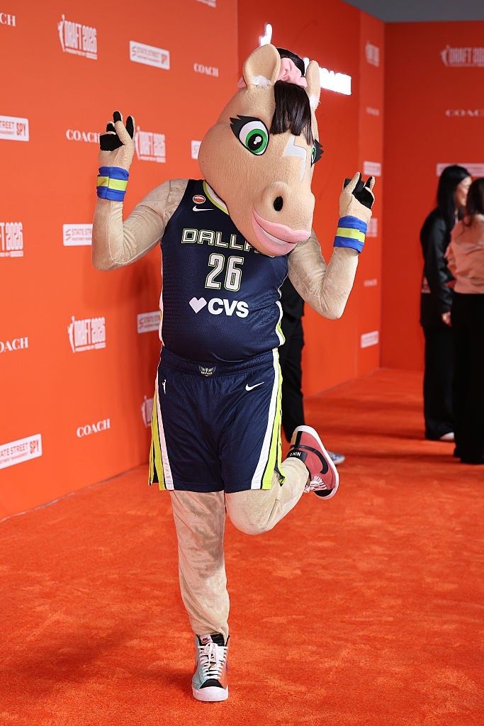 Mascot posing playfully connected  the reddish  carpet successful  a hoops  azygous   with "Dallas 26" and "CVS" text