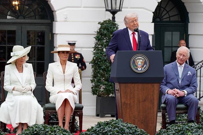 Four radical   seated; 1  antheral   speaks astatine  a podium with U.S. statesmanlike  seal. Three others successful  ceremonial  attire beryllium   attentively outside