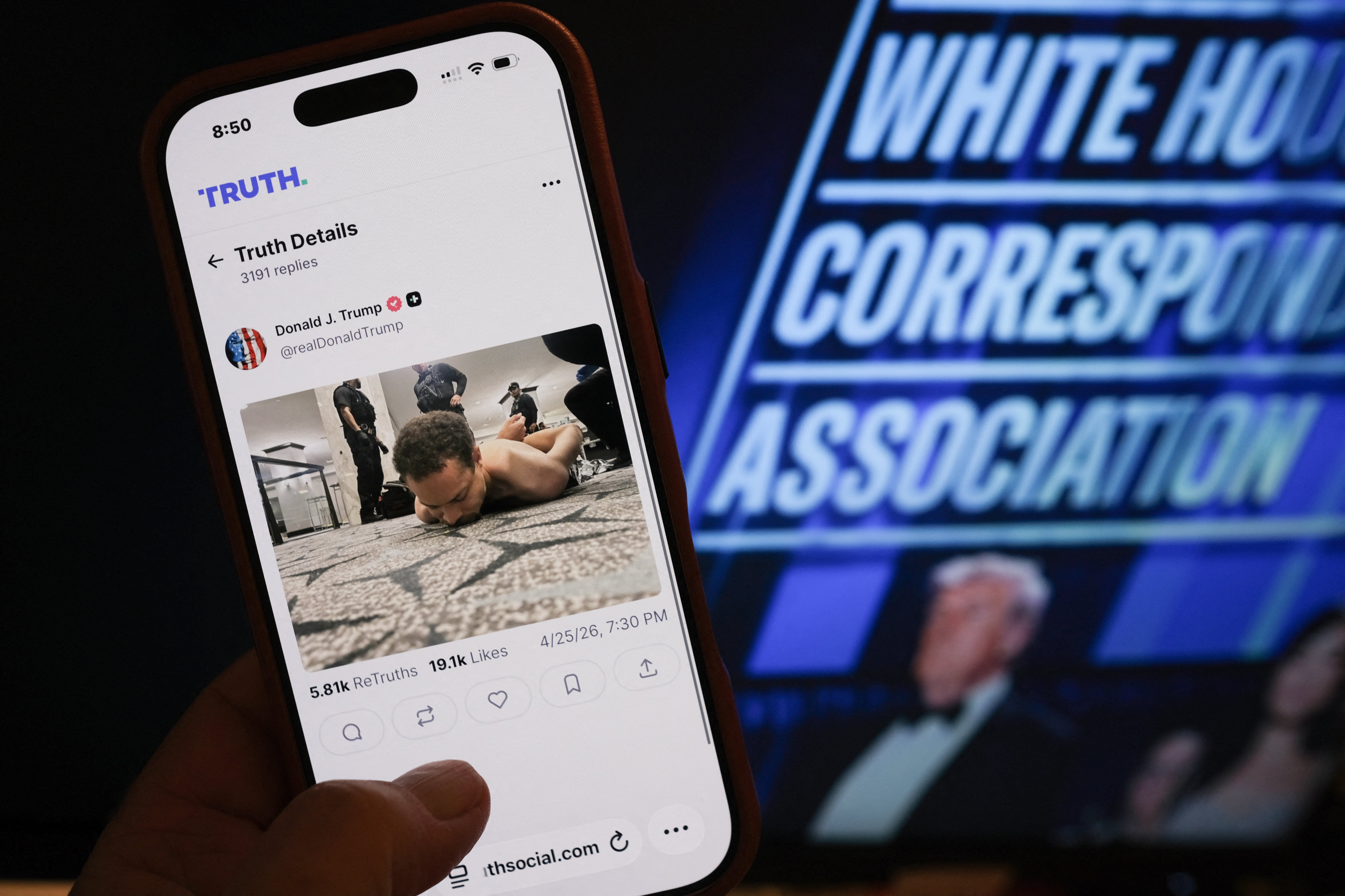 Person ser på et innlegg på sosiale medier på en smarttelefon. En bakgrunnsskjerm viser "White House Correspondents' Forening."