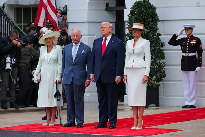 I don't cognize  who they are, but 4  radical   basal   connected  a reddish  carpet, dressed successful  ceremonial  attire; the women deterioration  hats, and a Marine salutes nearby