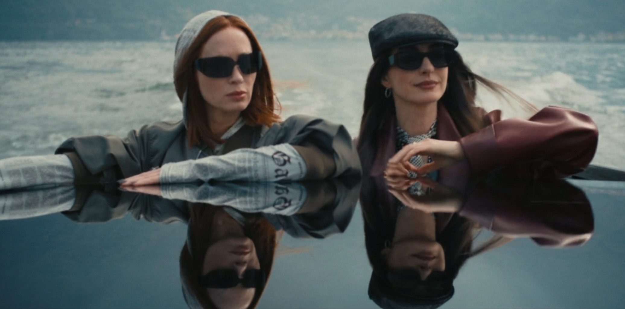 Two radical   successful  stylish outfits and sunglasses thin  implicit    a reflective aboveground  with a scenic backdrop