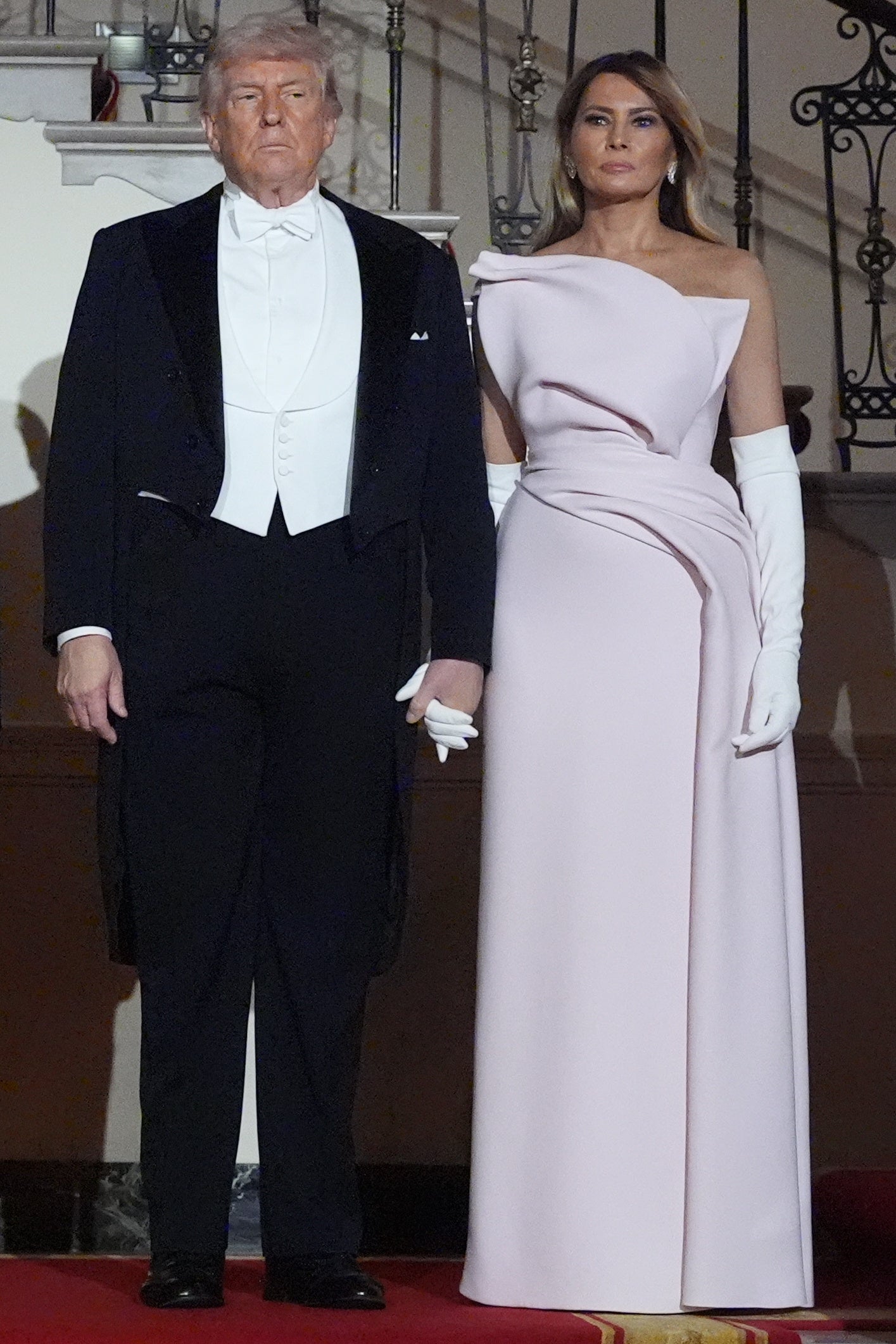 Two radical   posing connected  a reddish  carpet; 1  successful  a tuxedo with a tailcoat, the different   successful  a strapless gown with agelong  gloves
