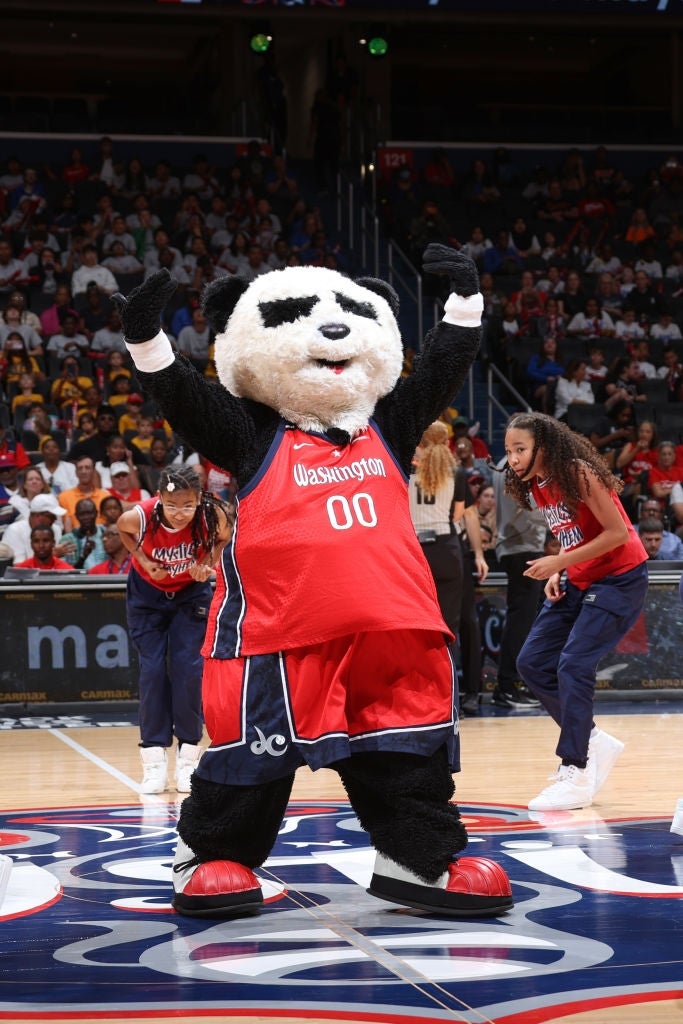 Basketball mascot, dressed arsenic  a panda successful  a jersey, entertains fans connected  the tribunal  during a game