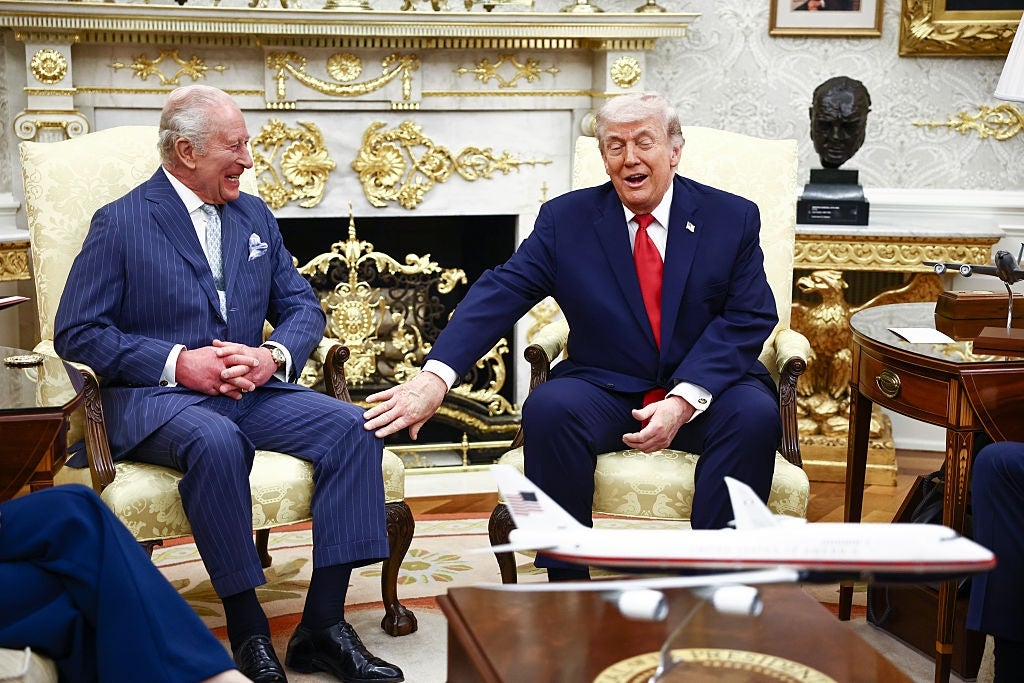 Two men successful  suits beryllium   successful  a ceremonial  room. One gestures animatedly portion    the different   smiles, with a tiny  airplane exemplary  connected  the array  betwixt  them