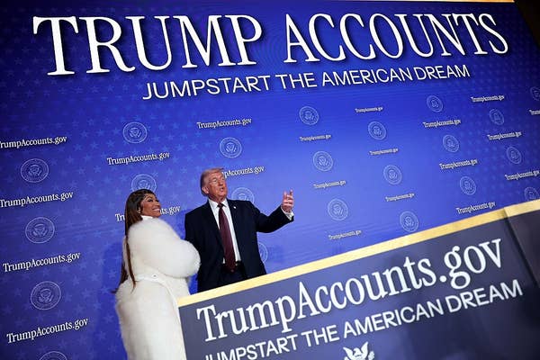 Two people stand in front of a backdrop reading "Trump Accounts" promoting a website, at a formal event