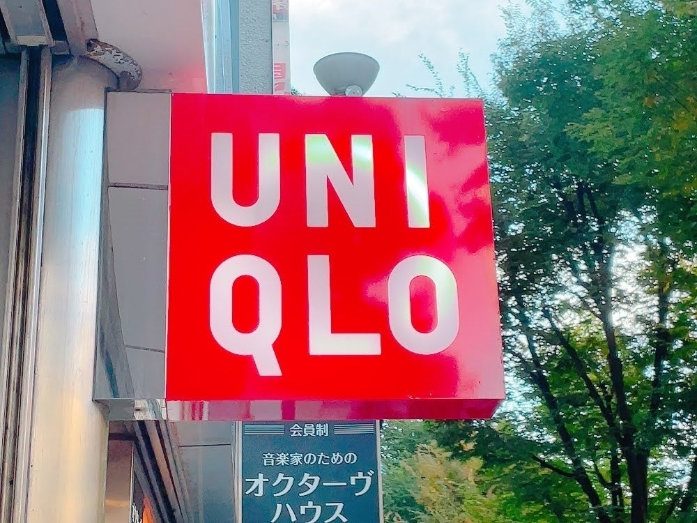 ユニクロの看板が見える街頭風景。背景には木々が写っています。
