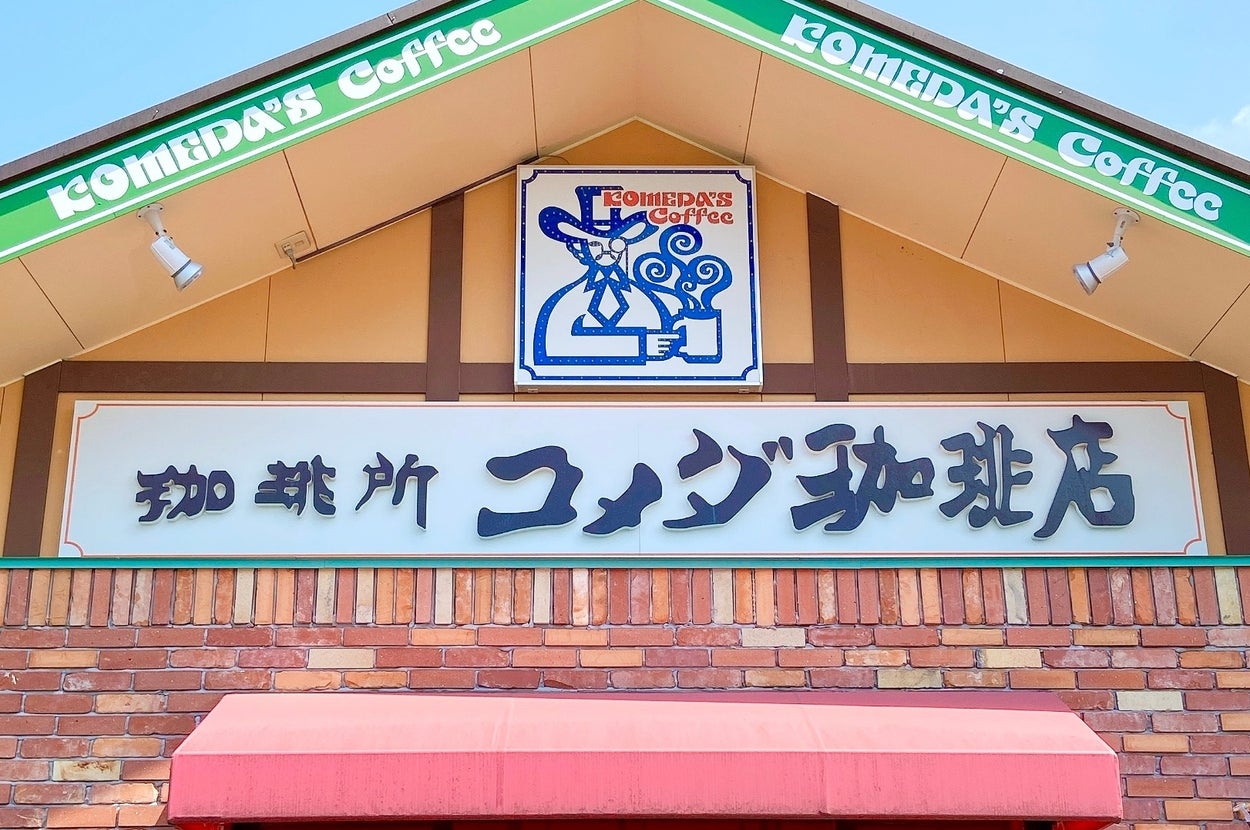 日本の喫茶店「コメダ珈琲店」の外観。レンガ造りのファサードに、店名の看板が掲示されています。