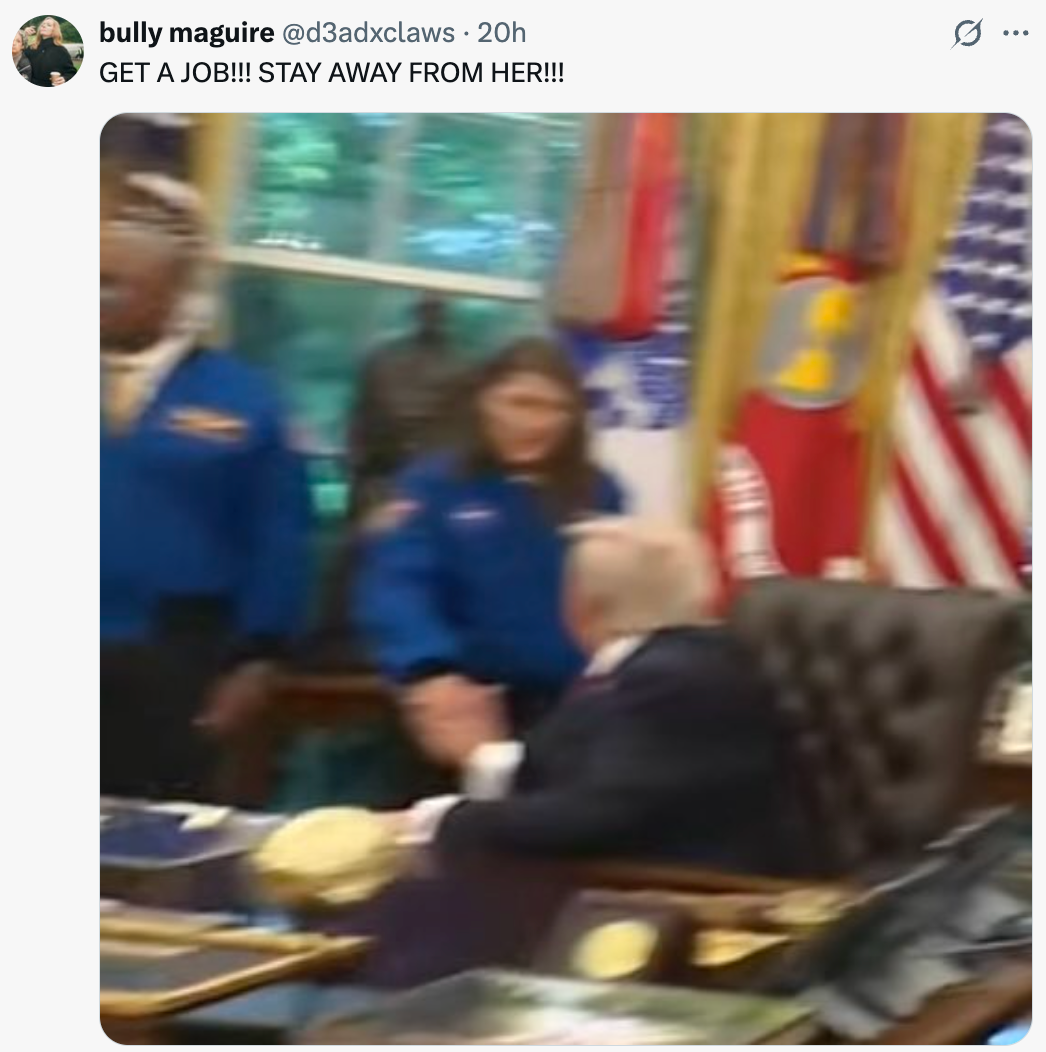 Folk kledd som astronauter på et kontor med flagg, håndhilser på en mann som sitter bak et skrivebord. Teksten lyder