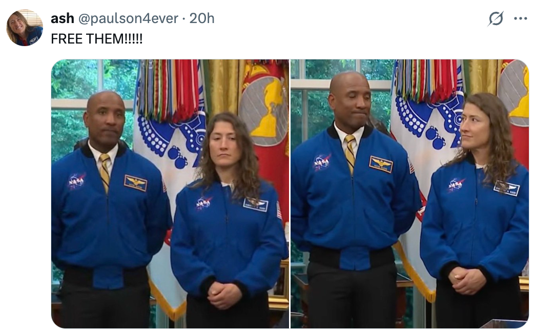 To personer i NASA-jakker står side om side, den ene ser på den andre, i et rom med militærflagg