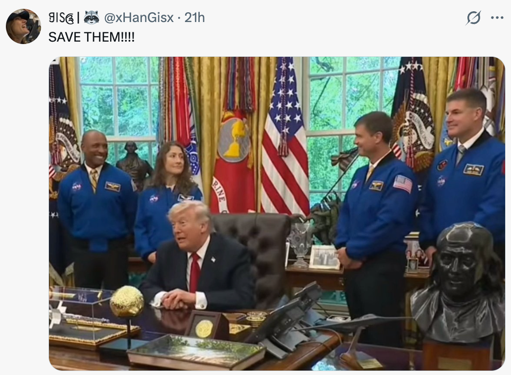 En gruppe på fire personer i NASA-jakker står rundt en person i dress som sitter ved et skrivebord i et formelt rom