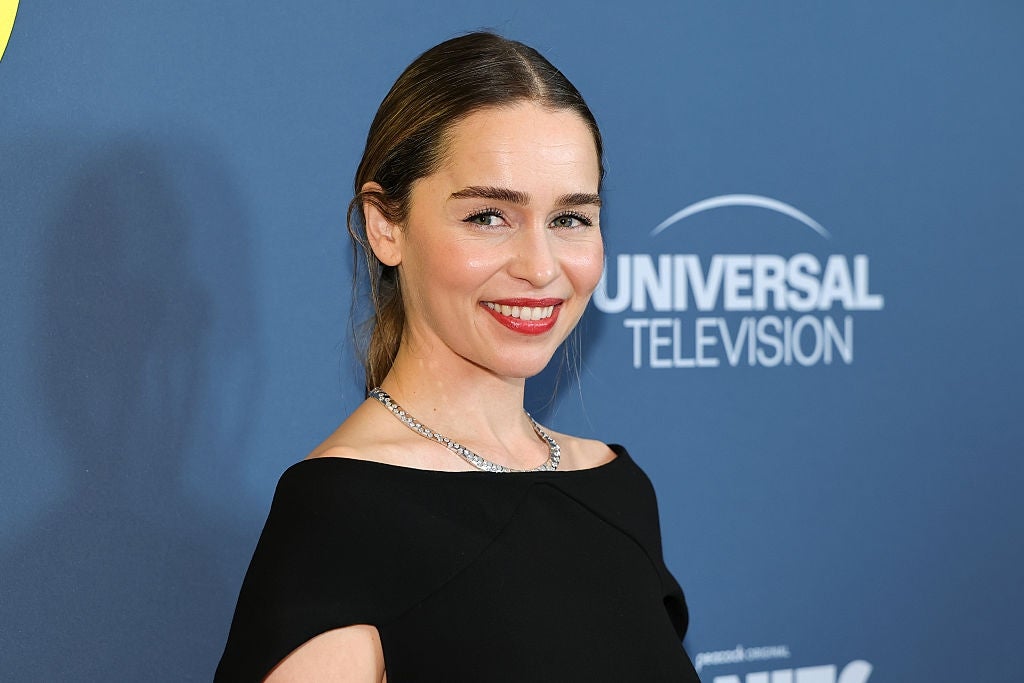 Person successful  elegant achromatic  formal  smiling astatine  a Universal Television event, lasting  against a bluish  backdrop with the logo