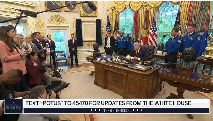 President sits astatine  Oval Office table  surrounded by NASA astronauts and press; reporters instrumentality     notes and photos