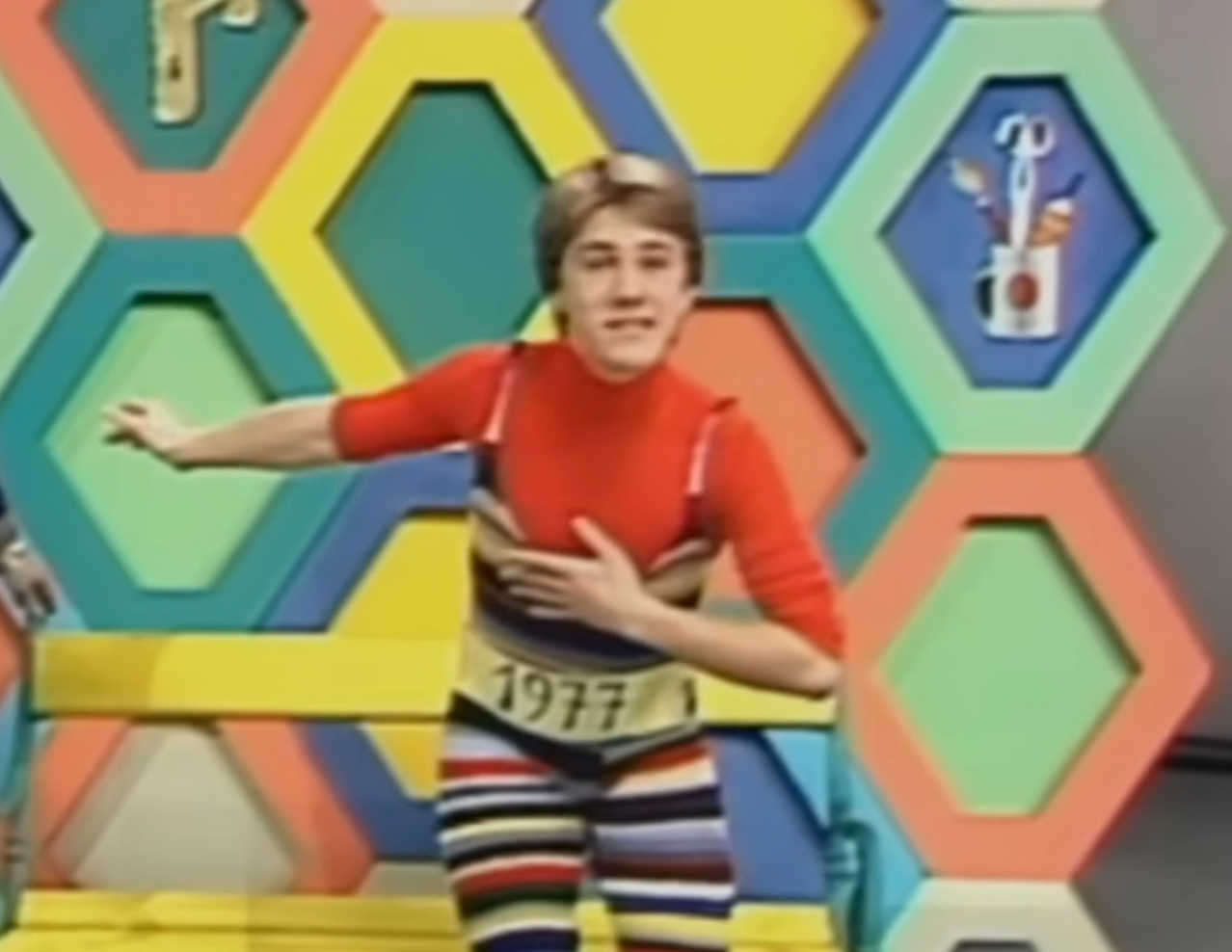 Person successful  a colorful striped outfit posing energetically connected  a 1970s-style crippled  amusement   acceptable   with honeycomb-patterned backdrop
