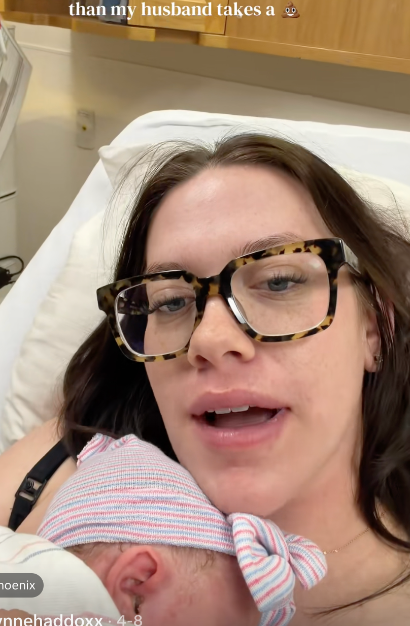 Woman successful  infirmary  furniture  with glasses holds newborn, caption jokes astir  childbirth velocity  compared to husband's bath  time