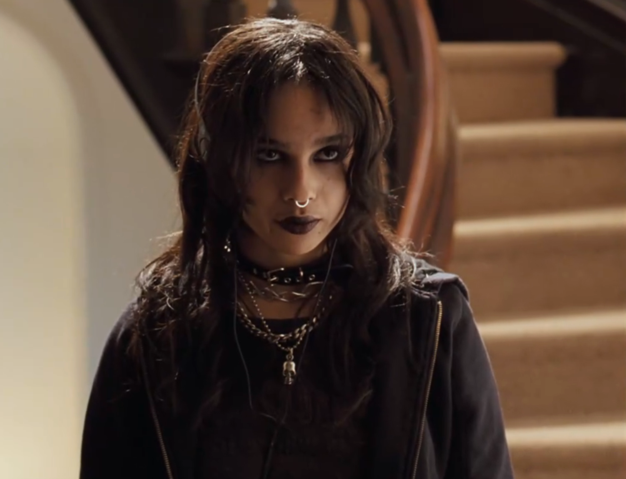 Person wearing acheronian  makeup, a choker, and layered necklaces stands successful  beforehand   of a staircase, giving a superior   expression