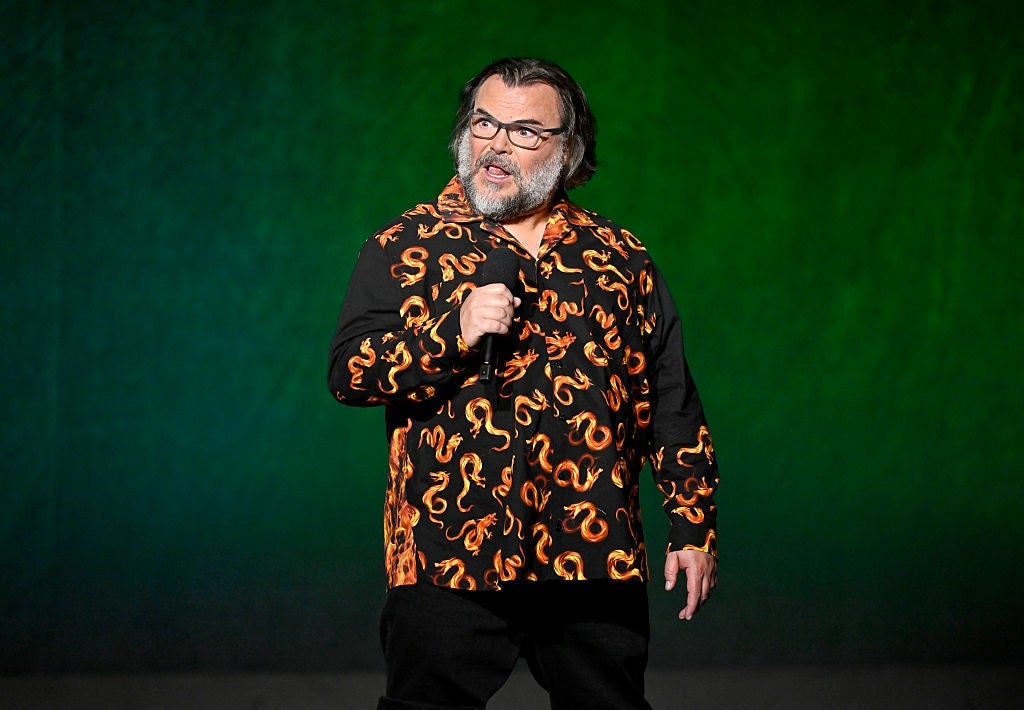 A idiosyncratic   connected  stage, wearing a garment  with a vibrant design, holding a microphone, with a focused expression