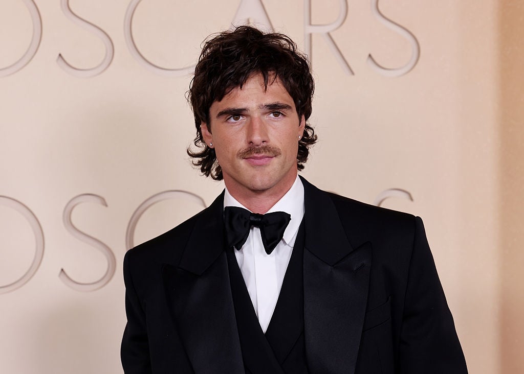 Person successful  a tuxedo with a bow necktie  connected  a ceremonial  reddish  carpet lawsuit   background