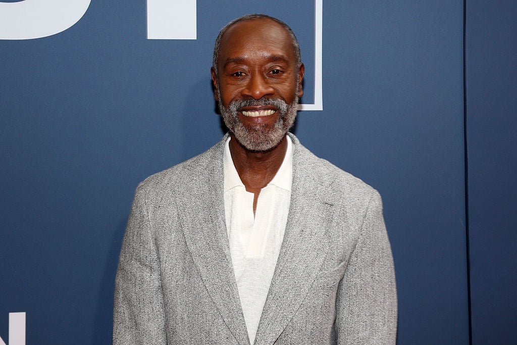 Person smiling, wearing a textured suit   overgarment   implicit    a airy  shirt, viewed against a plain backdrop