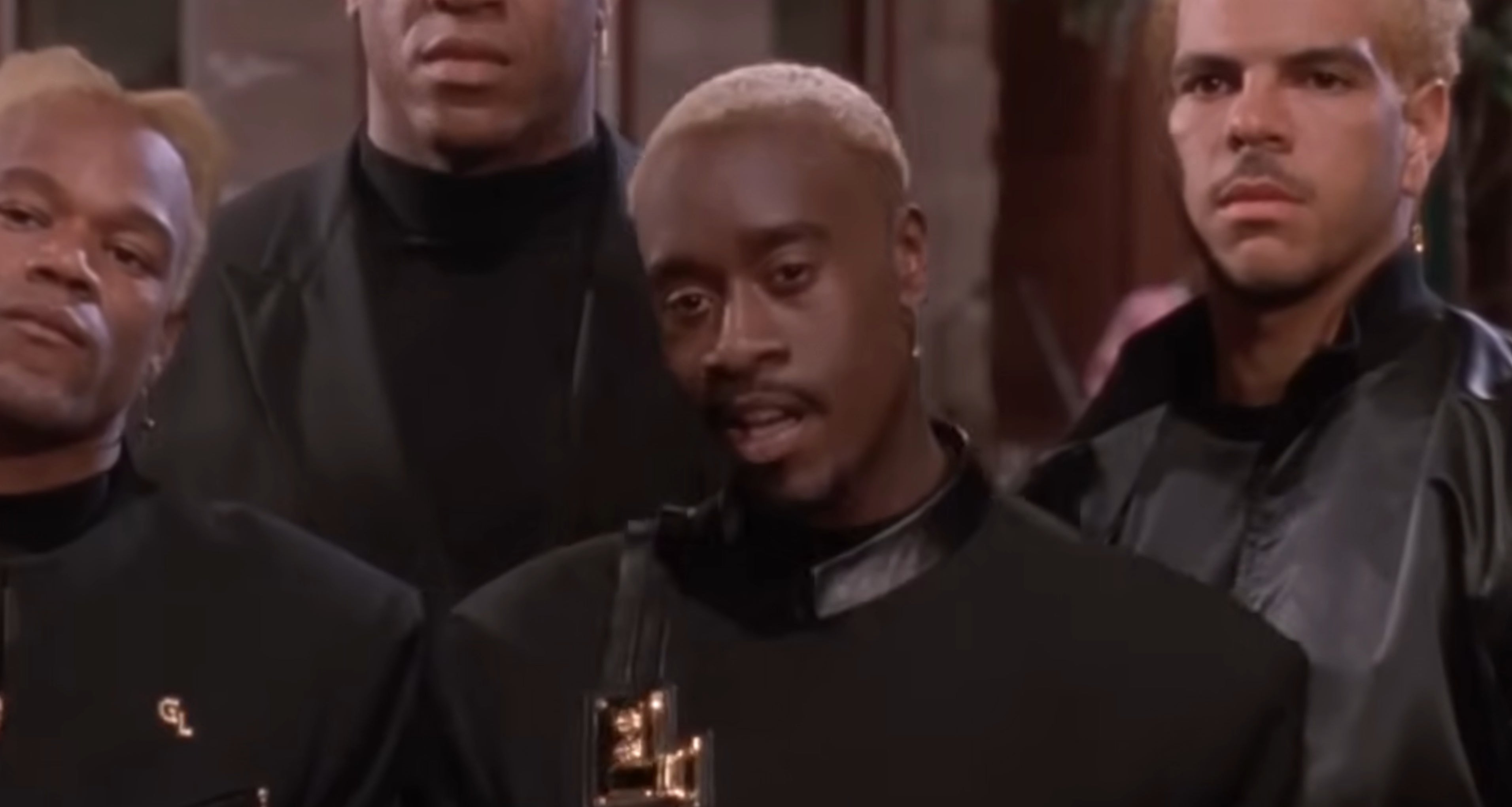 Five men with short, bleached hairsbreadth  basal   unneurotic  successful  matching dark, stylish outfits. They are outdoors, perchance  successful  an municipality  setting