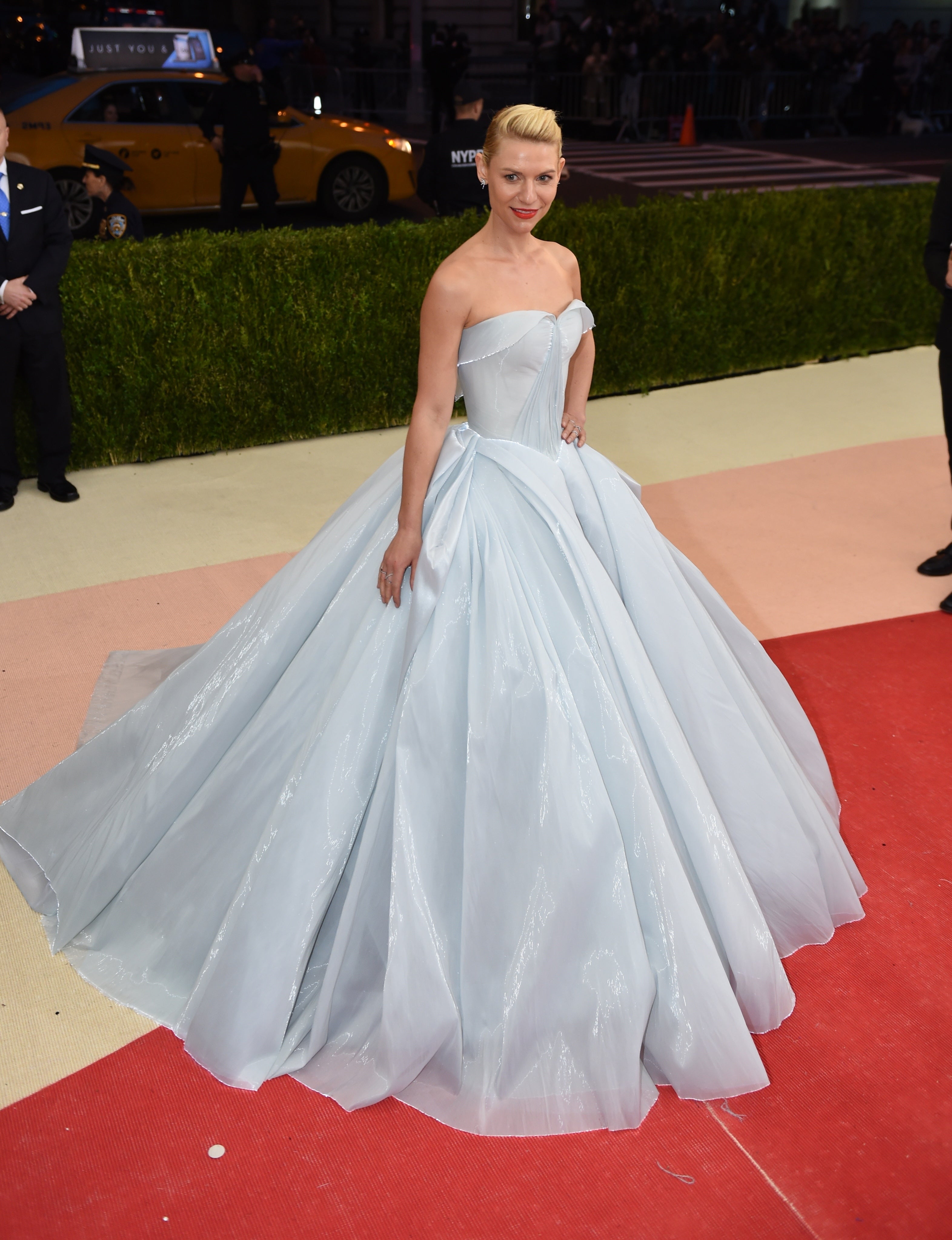 Person successful  an elegant strapless shot  gown poses connected  a reddish  carpet astatine  an event