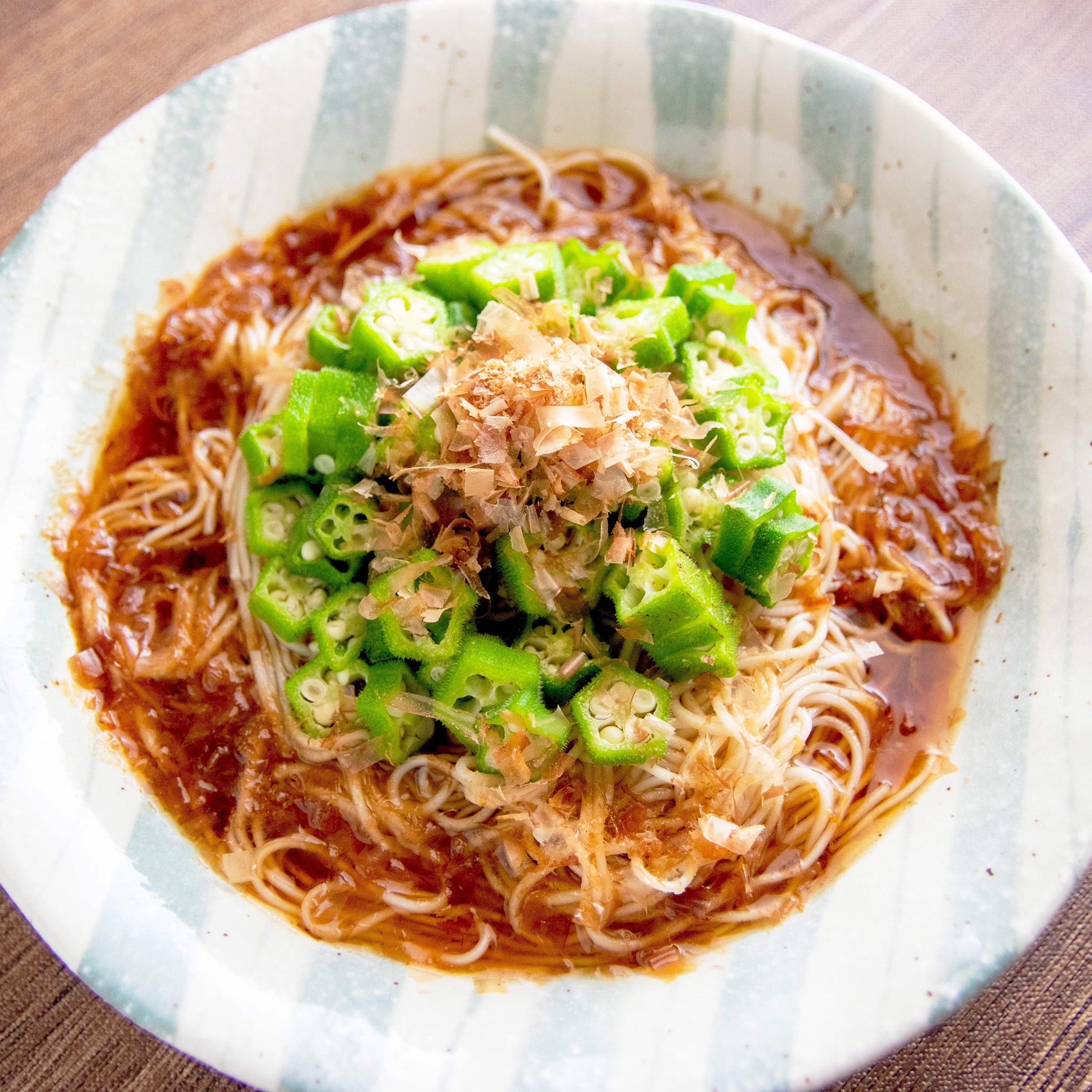 皿に盛られたそうめん。上には刻んだオクラと鰹節が乗っている。