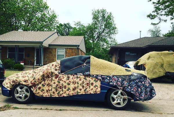 Car covered with assorted  patterned blankets successful  a residential neighborhood, apt  utilized  for prima   oregon  upwind  protection
