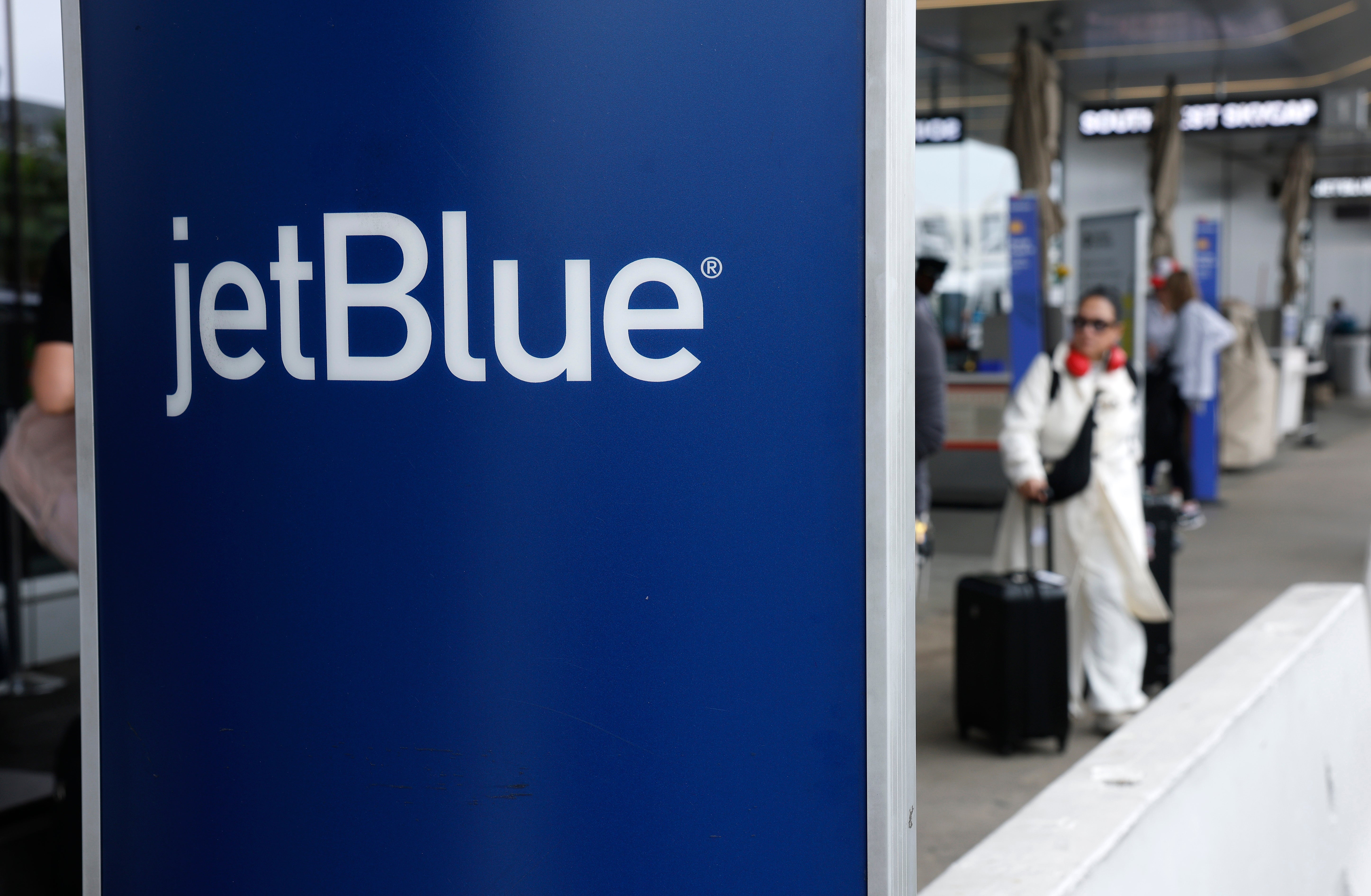 JetBlue motion   astatine  an airport, with travelers successful  the background