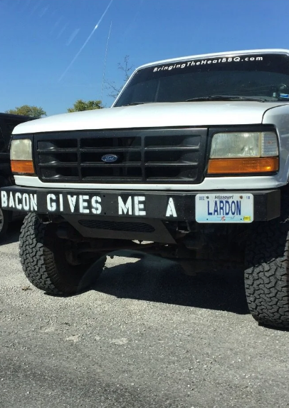 Front of a ample  motortruck  with a sheet  speechmaking  "LARDON" and a bumper sticker saying "BACON GIVES ME A."