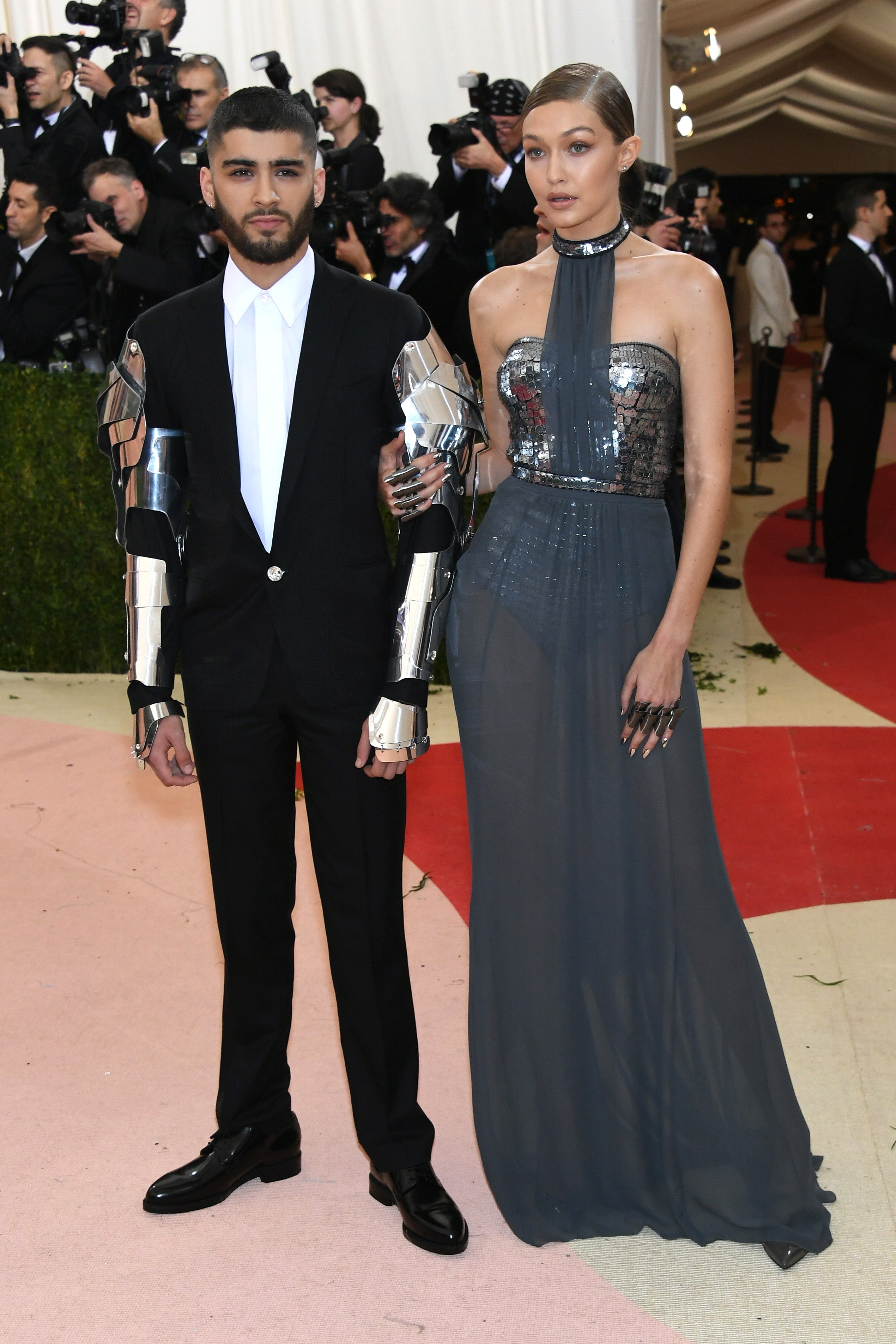 Two individuals connected  the reddish  carpet; 1  successful  a suit   with metallic limb  pieces, the different   successful  a halter-neck gown with sequin details