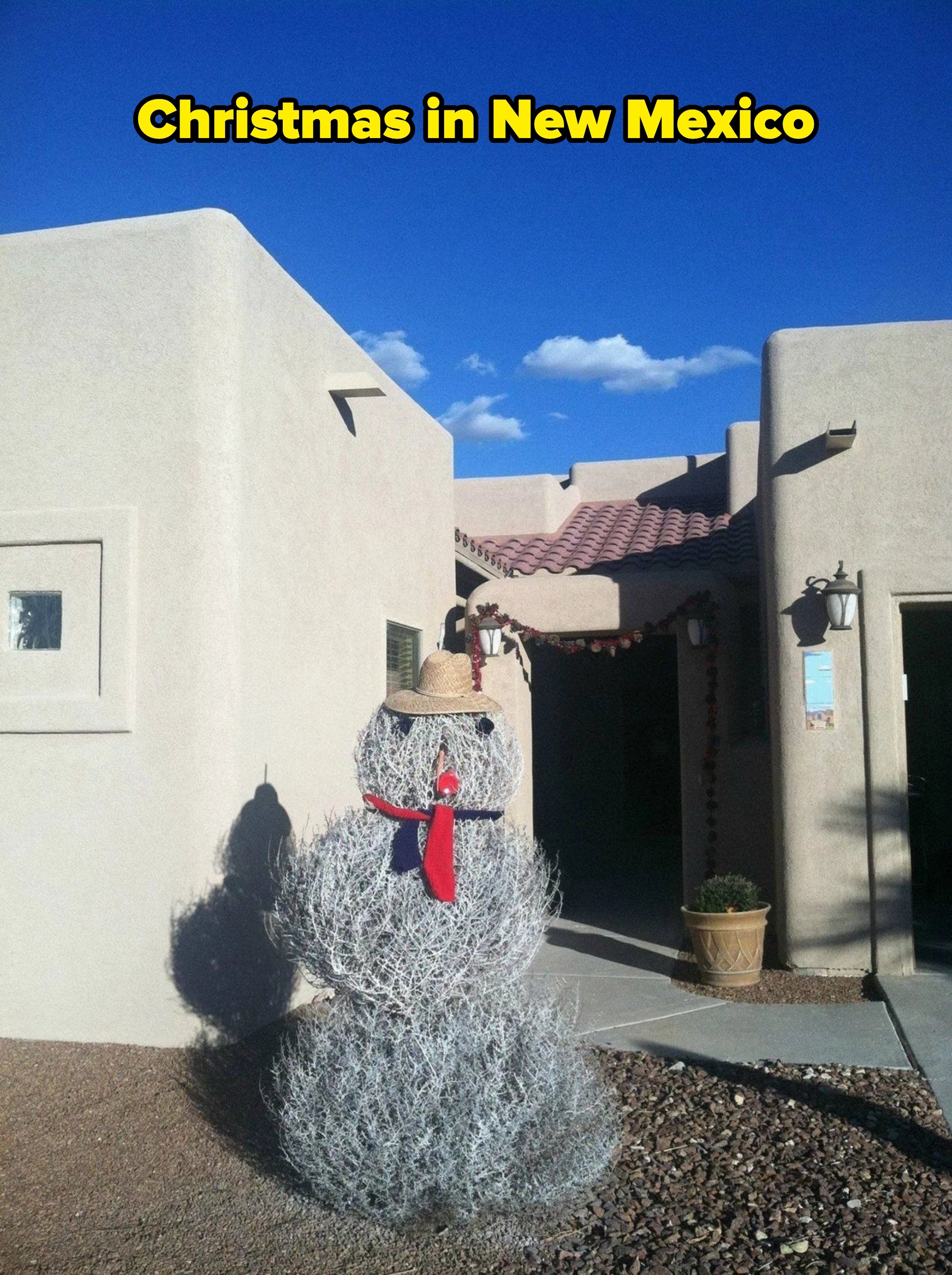 Tumbleweed snowman wearing a chapeau  and scarf successful  beforehand   of an adobe-style location   nether  a wide   sky
