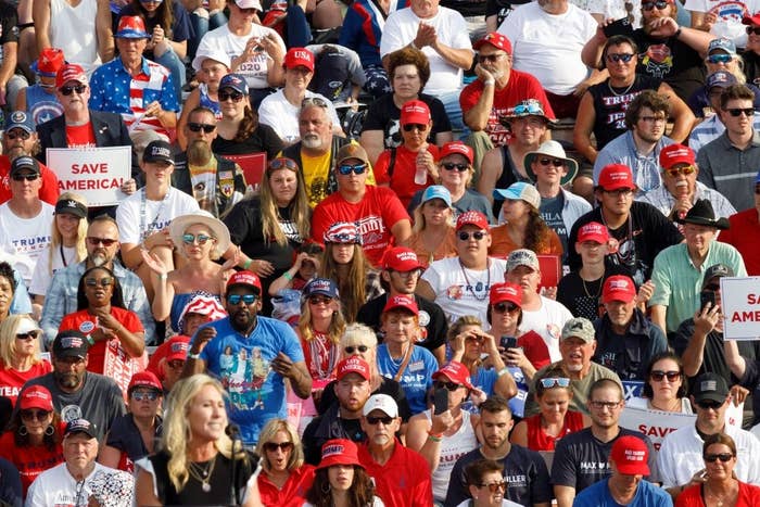 A ample  assemblage  astatine  a nationalist   rally, galore  wearing reddish  caps and holding "Save America" signs