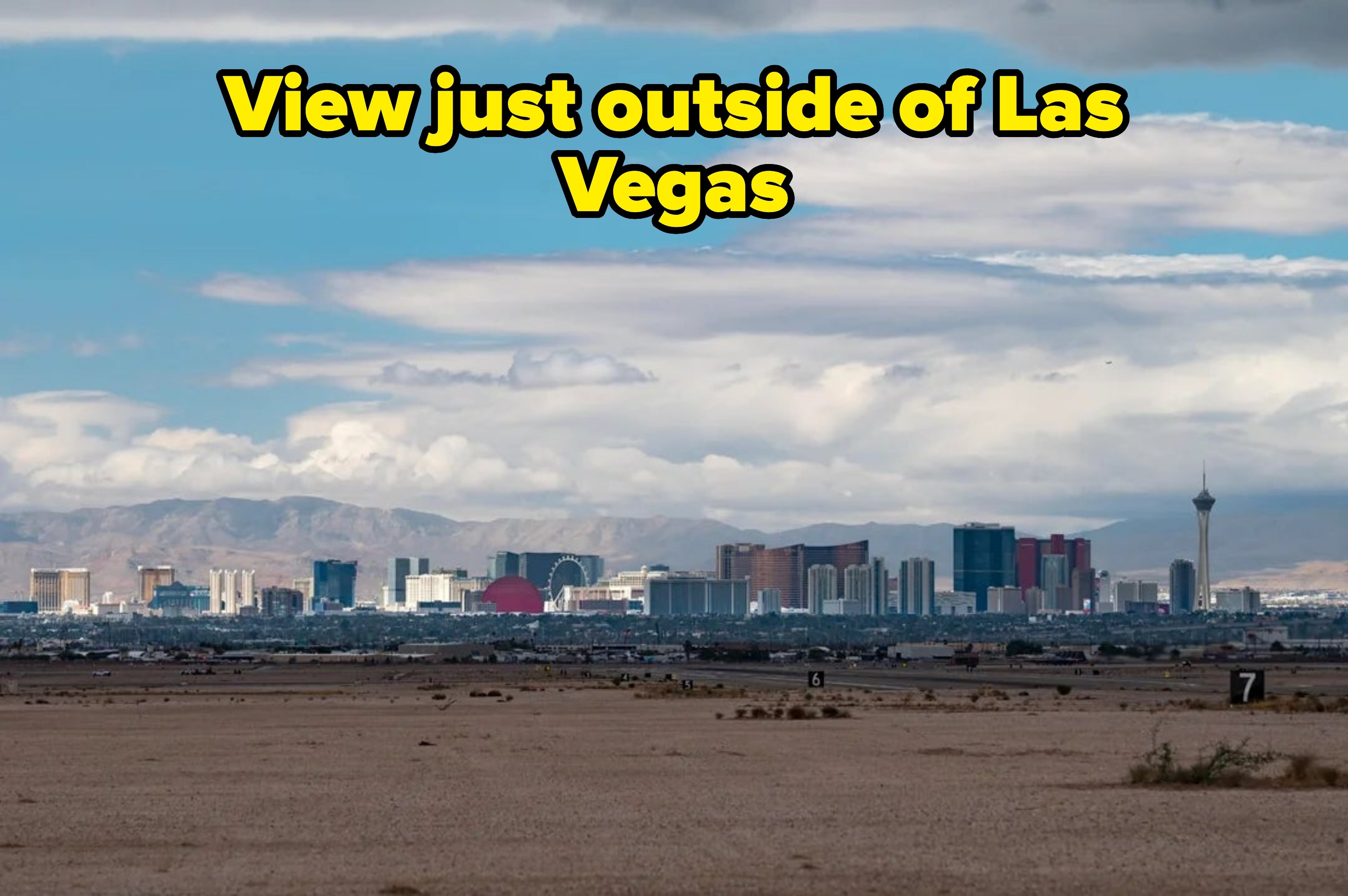 Skyline of Las Vegas with salient  buildings and a cloudy sky, viewed from a godforsaken  landscape