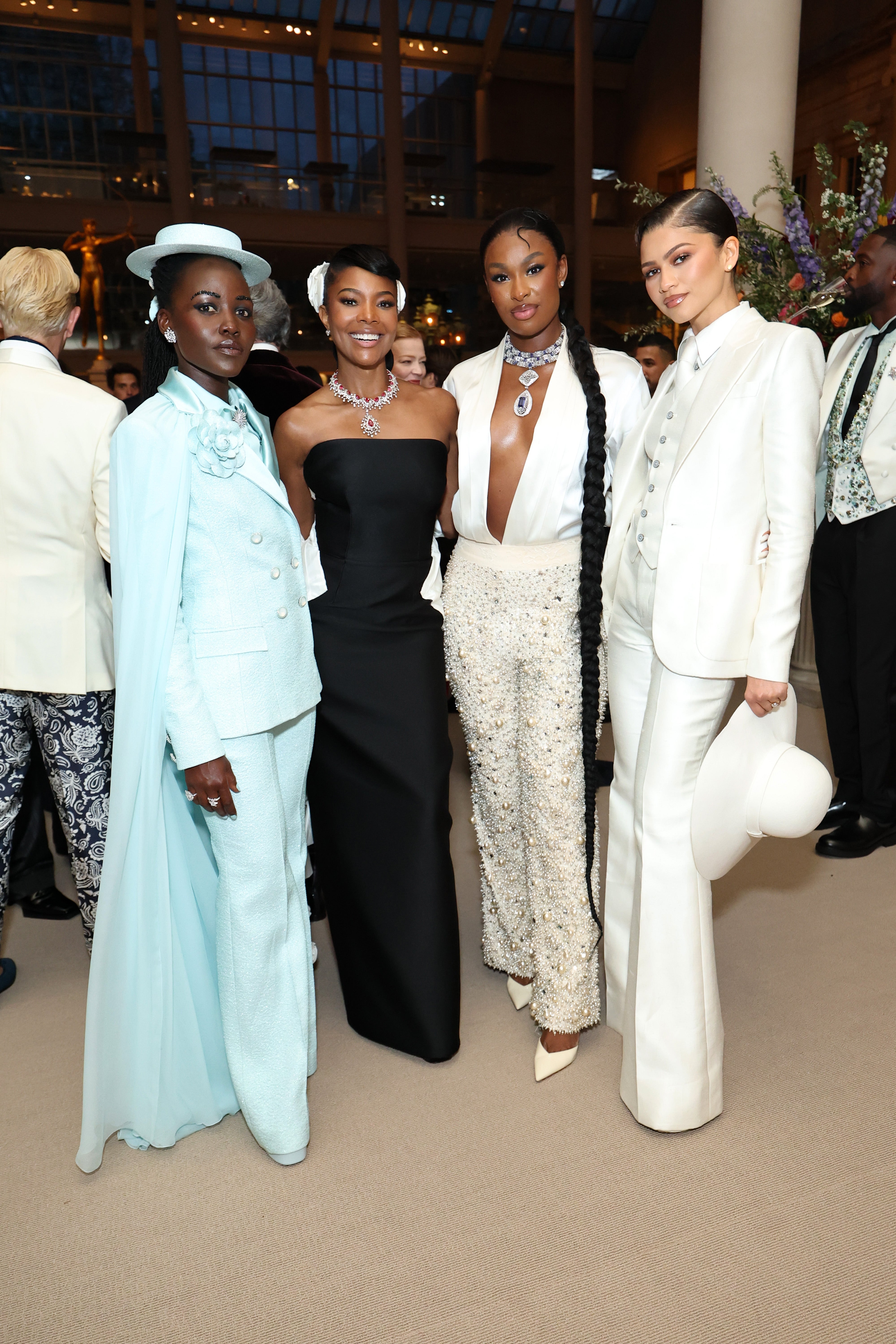  1  successful  a bluish  suit, 1  successful  a strapless achromatic  dress, 1  successful  a jeweled apical  and achromatic  pants, and 1  successful  a achromatic  suit   with a hat