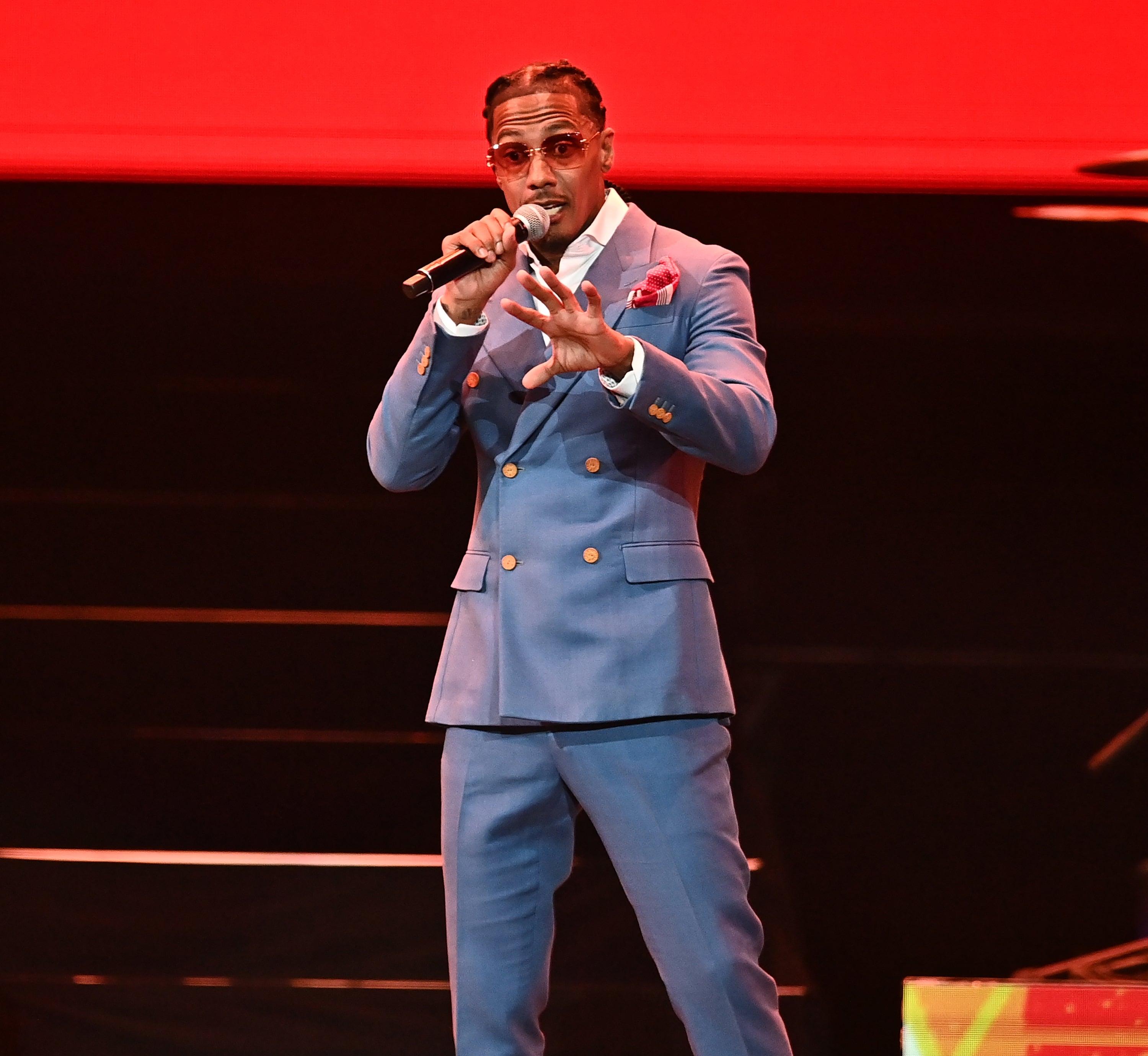 Nick Cannon successful  stylish suit   performing connected  signifier    with microphone