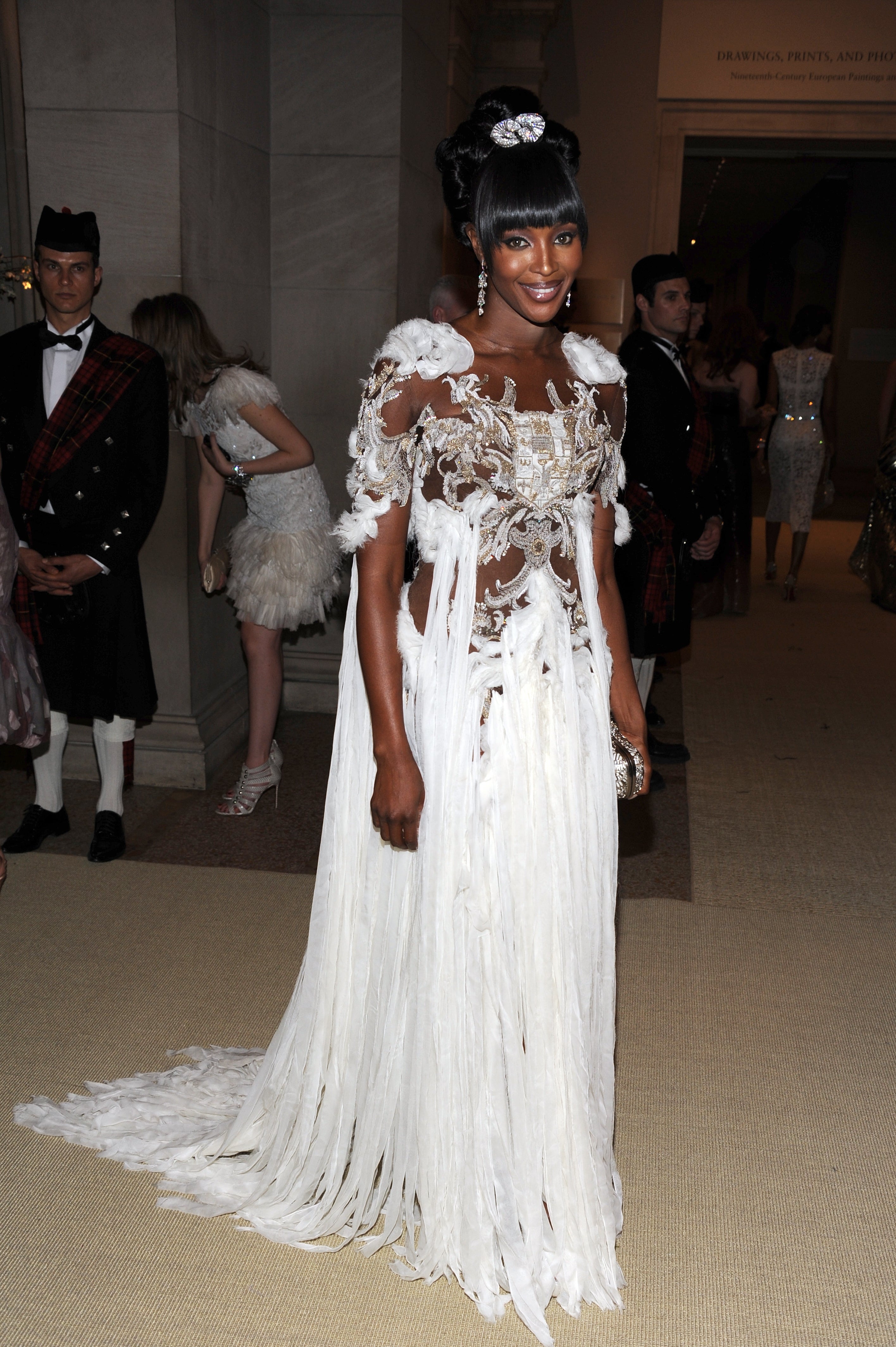 Person connected  a reddish  carpet successful  an intricately designed gown with feather details and a jeweled headpiece