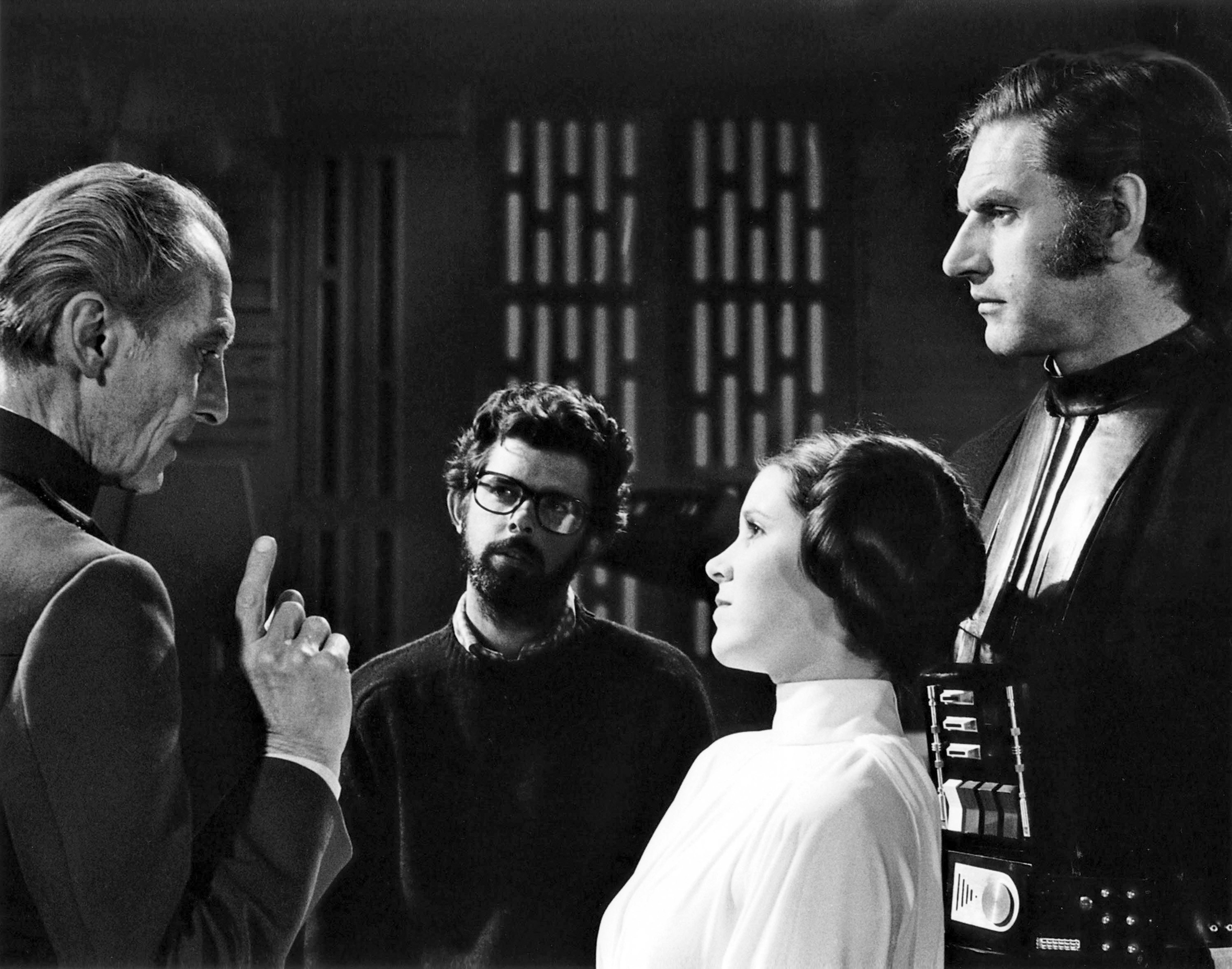 People connected  a movie  acceptable   discussing a scene. One idiosyncratic   wears a futuristic costume with a precocious   collar, the different   has a robe-style outfit with a precocious   neck