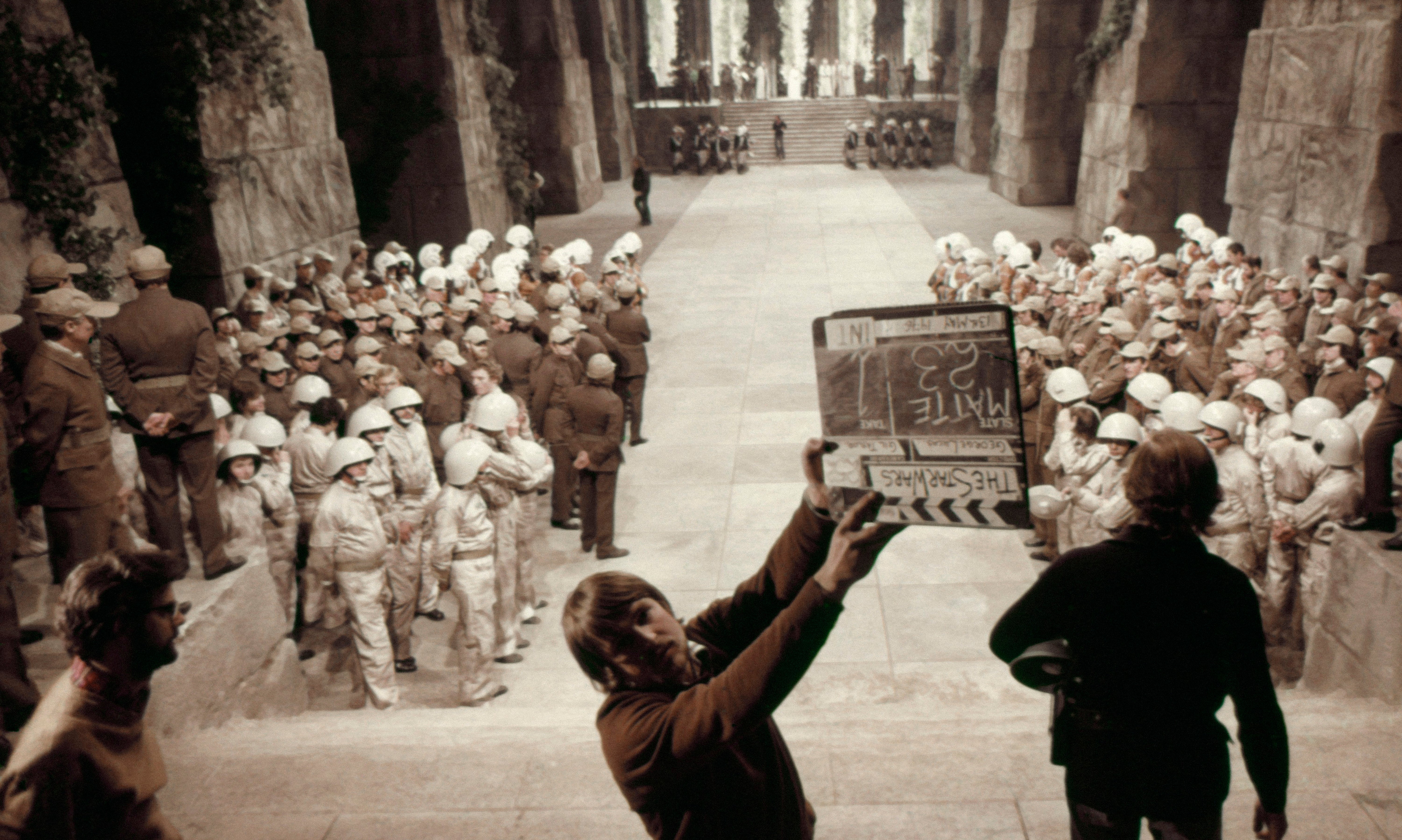 Behind-the-scenes photograph  of a movie   acceptable   with unit  and actors successful  sci-fi attire, a idiosyncratic   holds a movie  clapboard successful  the foreground