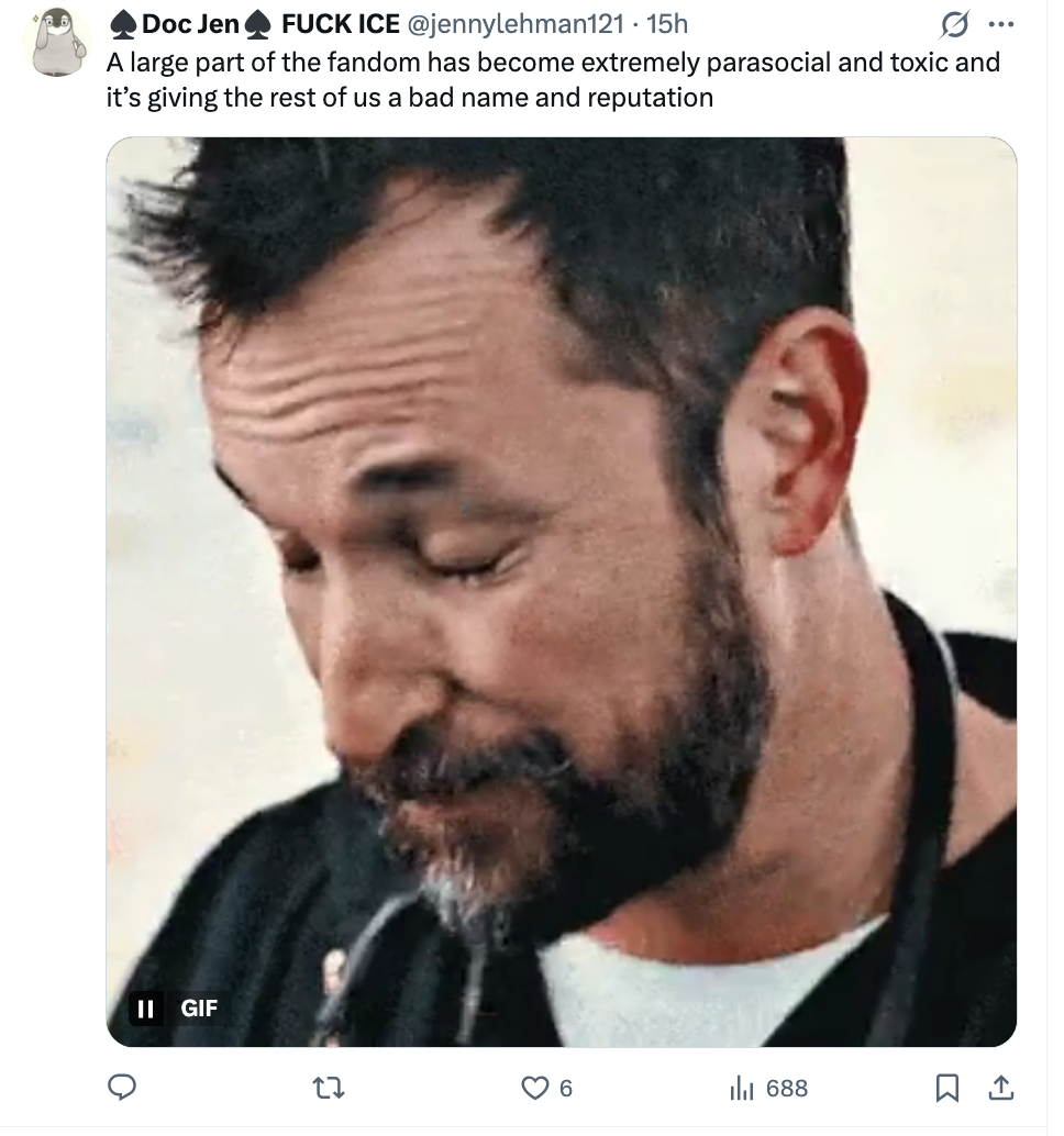 Person successful  GIF looks down   and smiles slightly. Social media station  astir  fandom toxicity and its interaction   connected  reputation