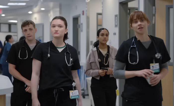 Four aesculapian  professionals locomotion  down   a infirmary  corridor successful  scrubs, focused and engaged