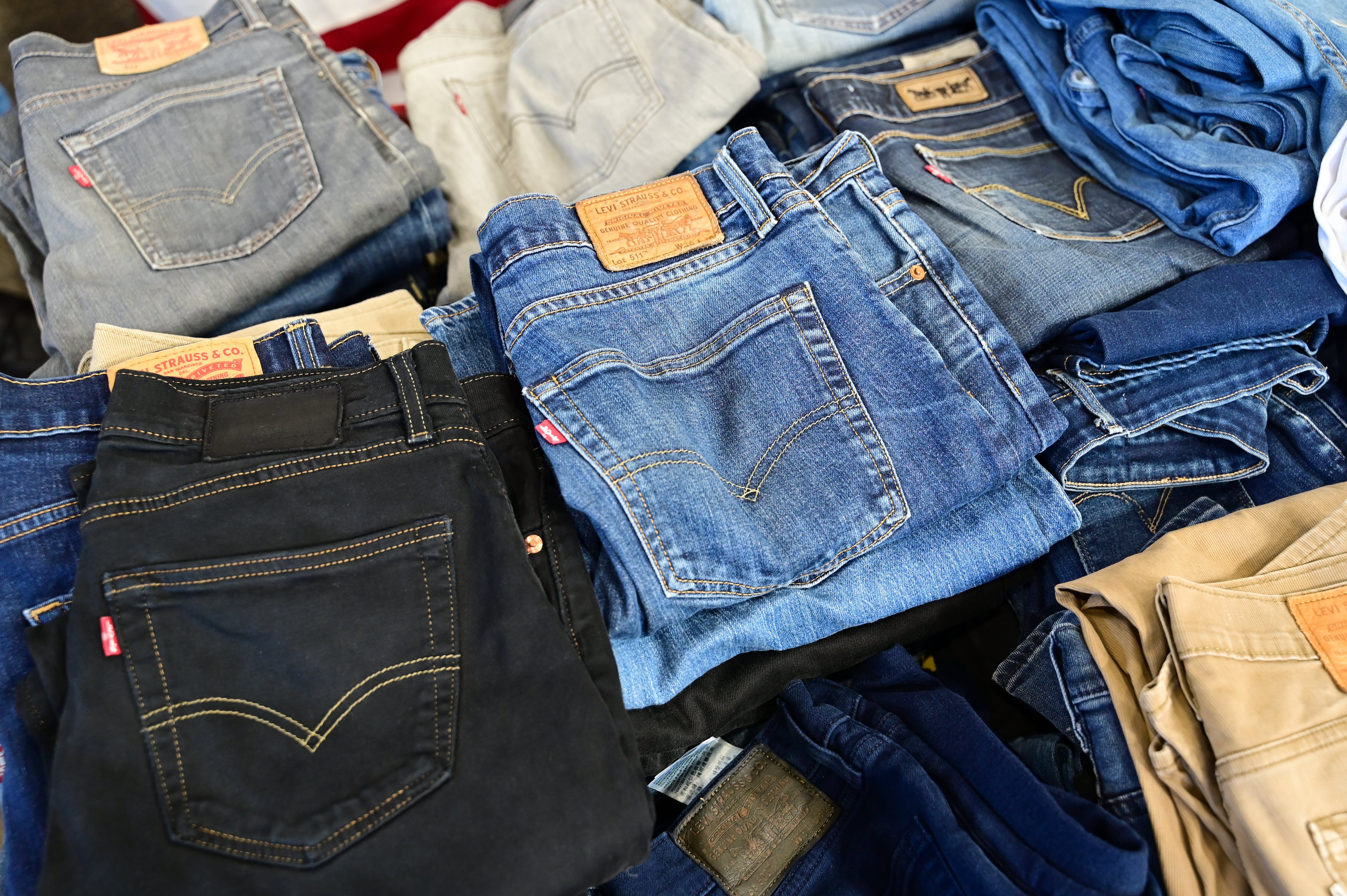 Stacks of folded jeans successful assorted styles and shades connected display, illustrating manner options for travelers