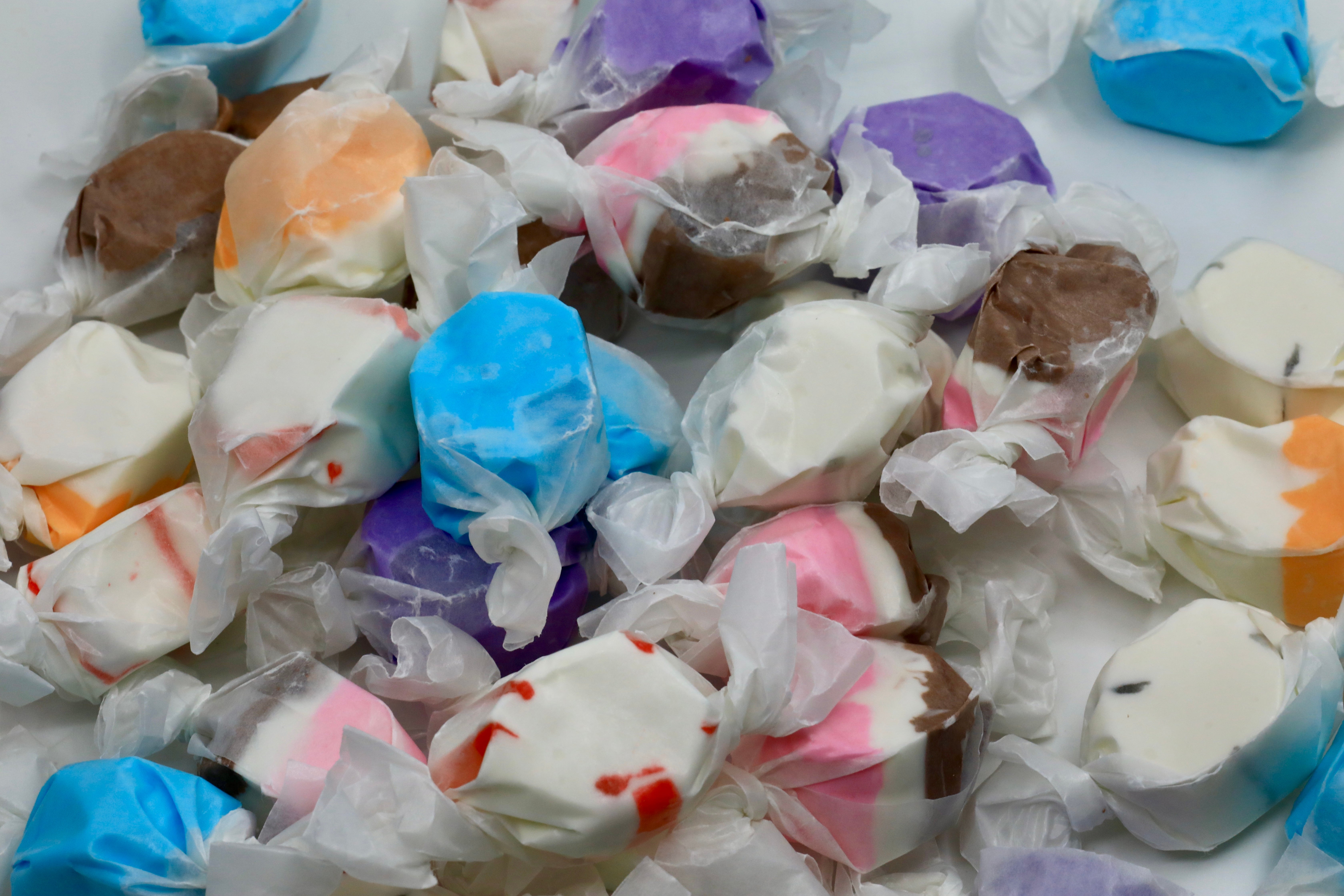 Assorted saltwater taffy pieces are scattered, wrapped successful transparent paper