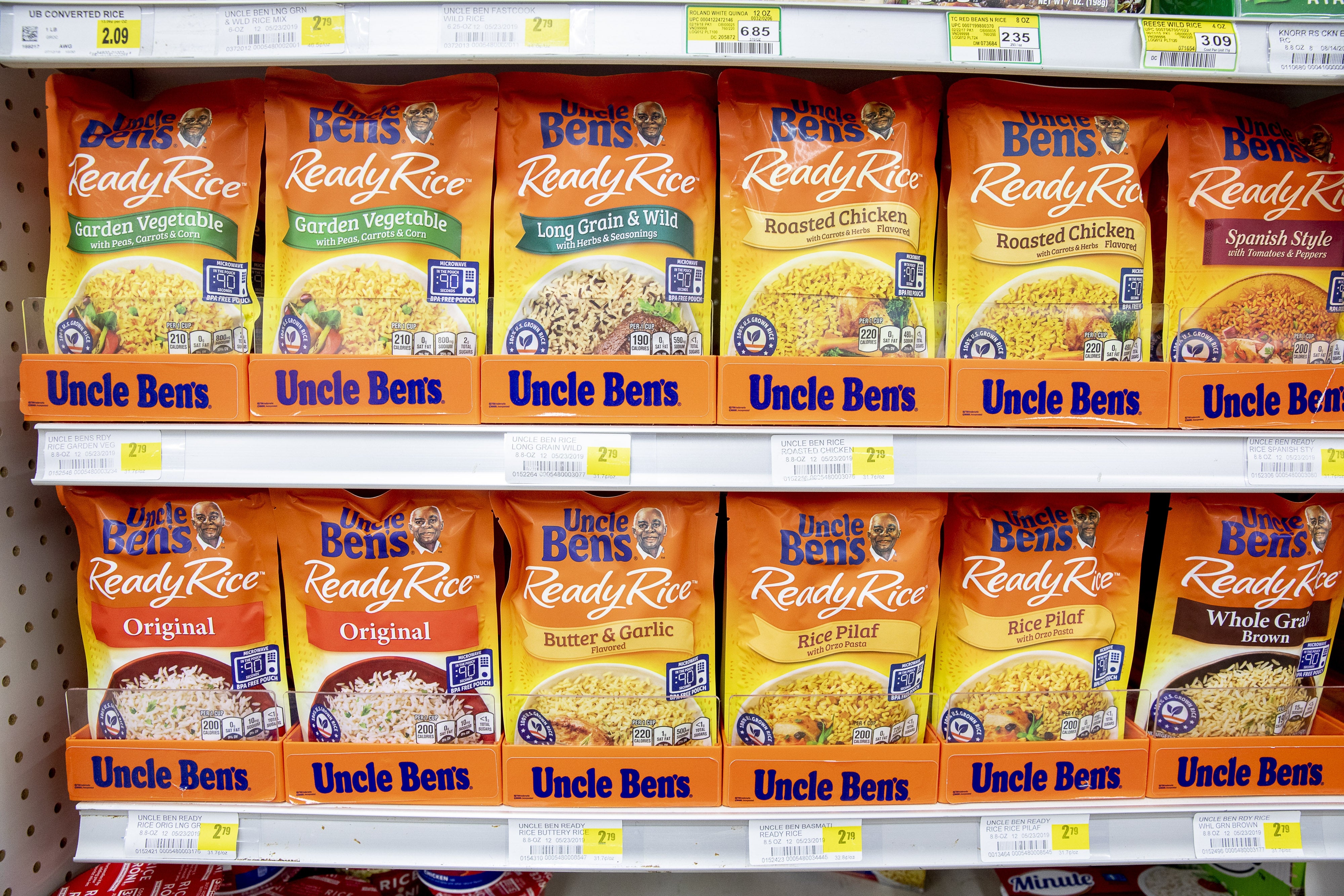 Grocery store support displaying assorted Uncle Ben's Ready Rice flavors, including Original, Roasted Chicken, and Spanish Style