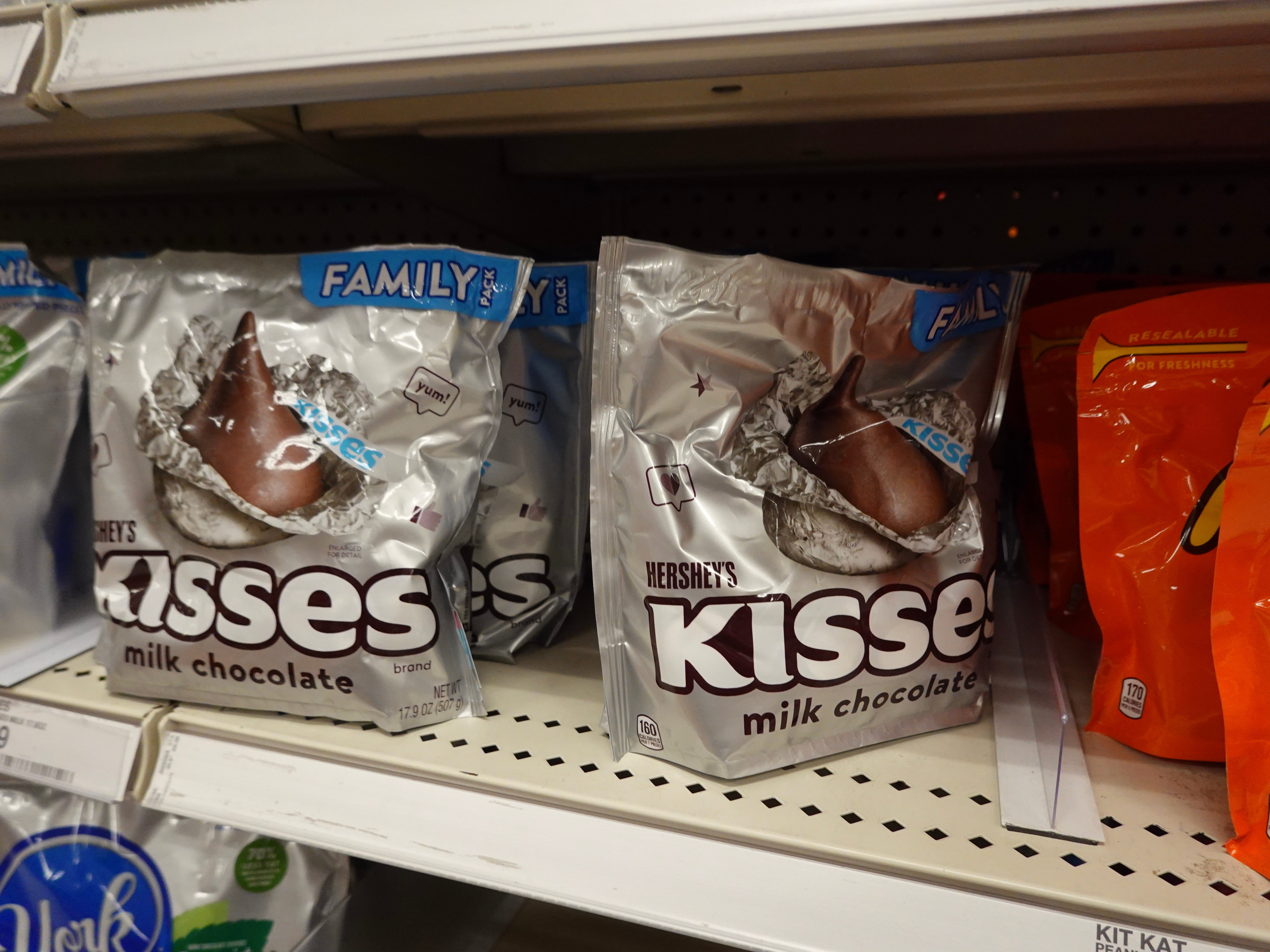 Hershey's Kisses beverage cocoa bags are displayed connected a store shelf, suggesting availability for travelers seeking saccharine snacks