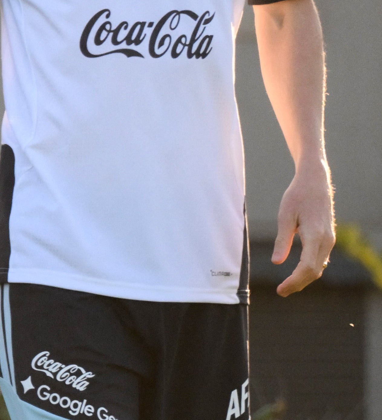 A antheral   smiles portion    wearing a sports grooming  outfit with sponsor logos