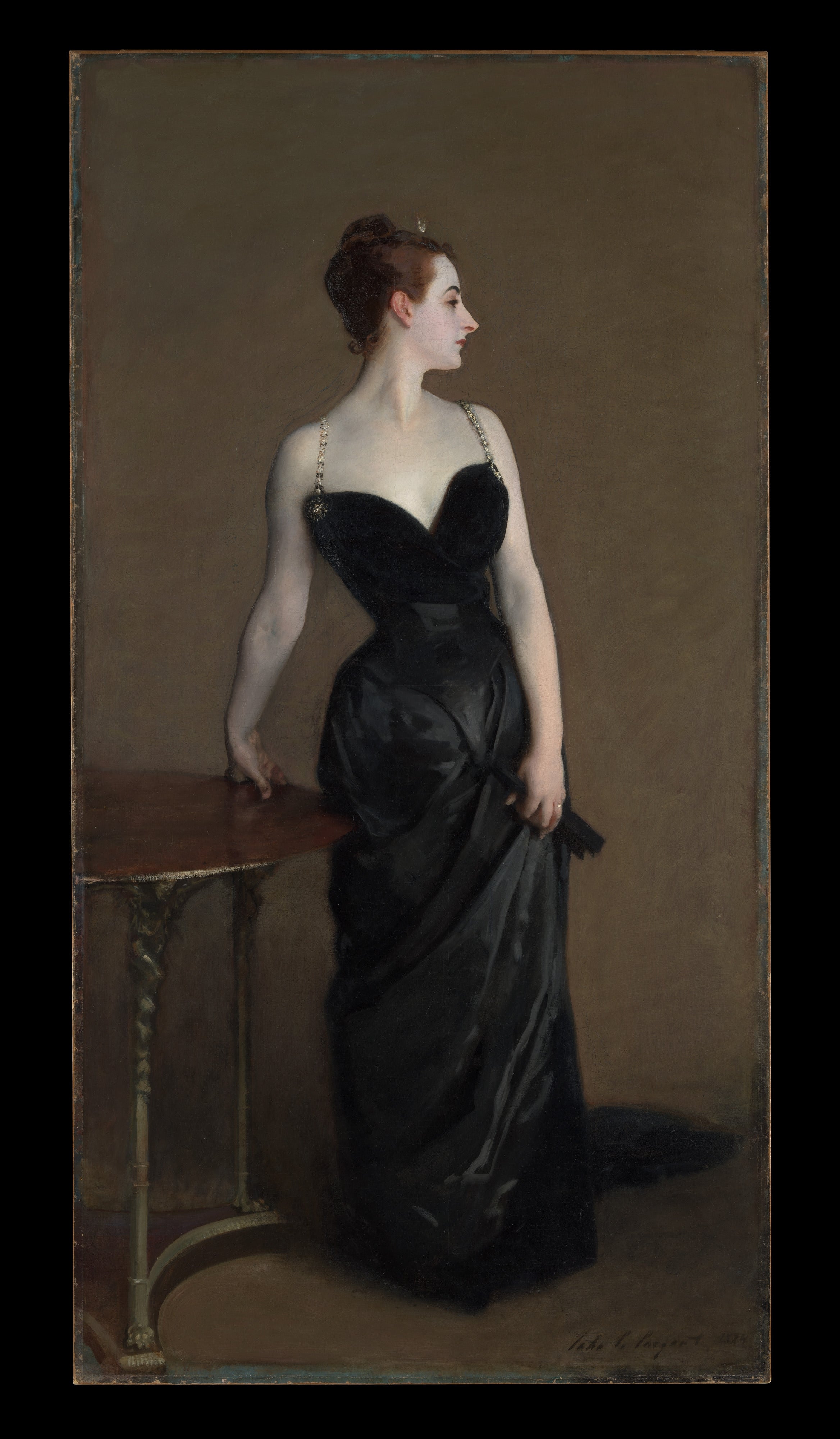 Portrait of a pistillate   successful  a black, elegant gown, lasting  beside a table, looking to the side