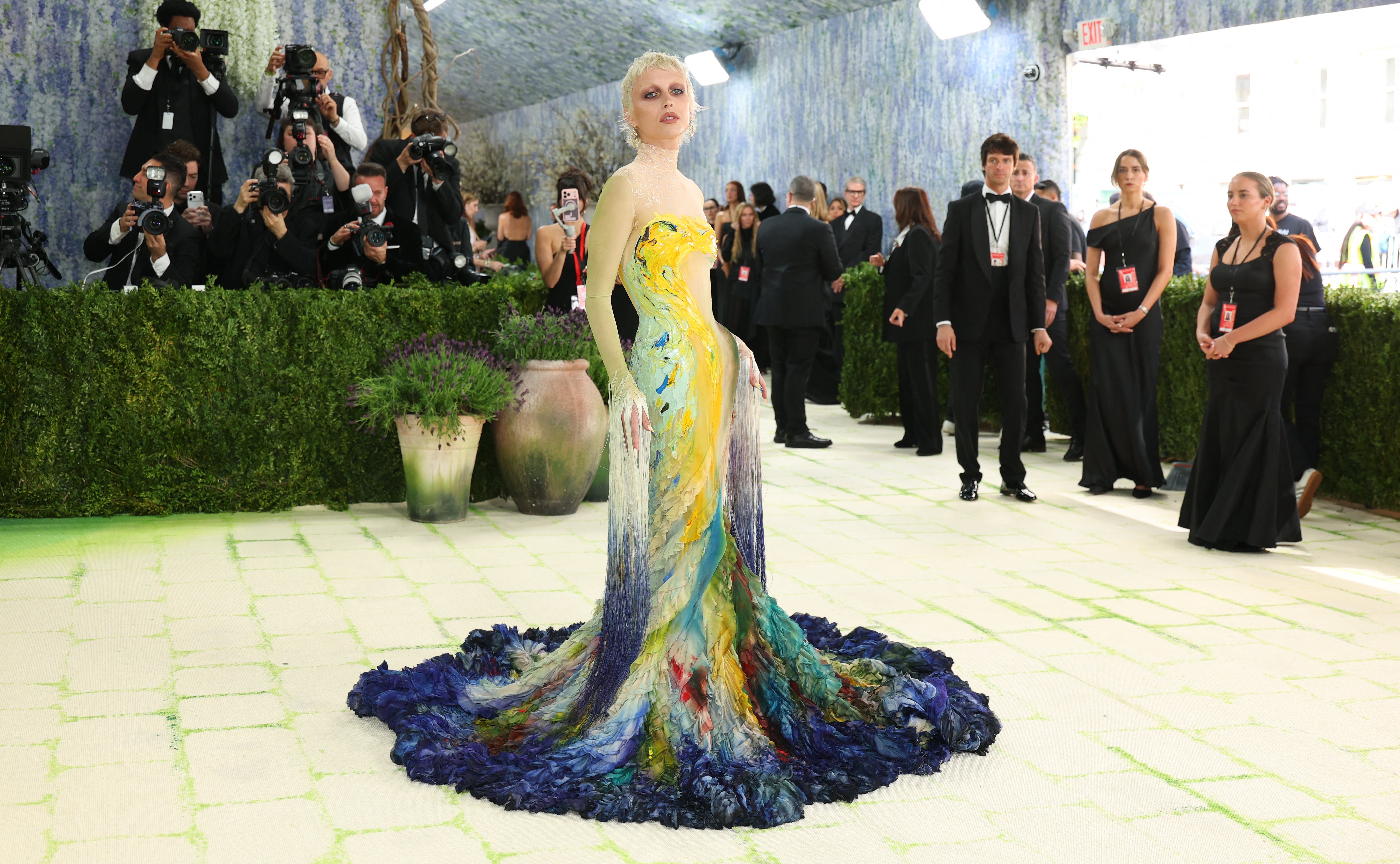 Emma Chamberlain successful  a multicolored gown with flowing train, lasting  connected  a ceremonial  lawsuit   carpet, surrounded by onlookers and photographers