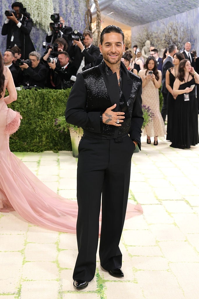 Celebrity successful  a achromatic  embellished suit   smiling connected  a ceremonial  lawsuit   carpet, with photographers successful  the background