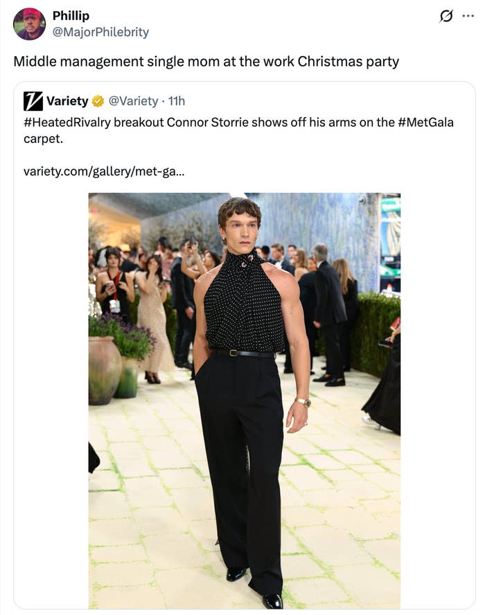 Tweet yang menampilkan foto seorang pria mengenakan atasan tanpa lengan berleher tinggi dan celana hitam di acara formal