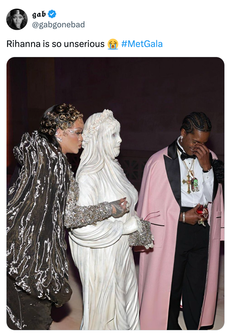 Tiga orang di Met Gala; yang satu mengenakan hiasan perak, yang lain mengenakan gaun putih berukir, dan yang ketiga mengenakan jubah merah muda di atas setelan jas.