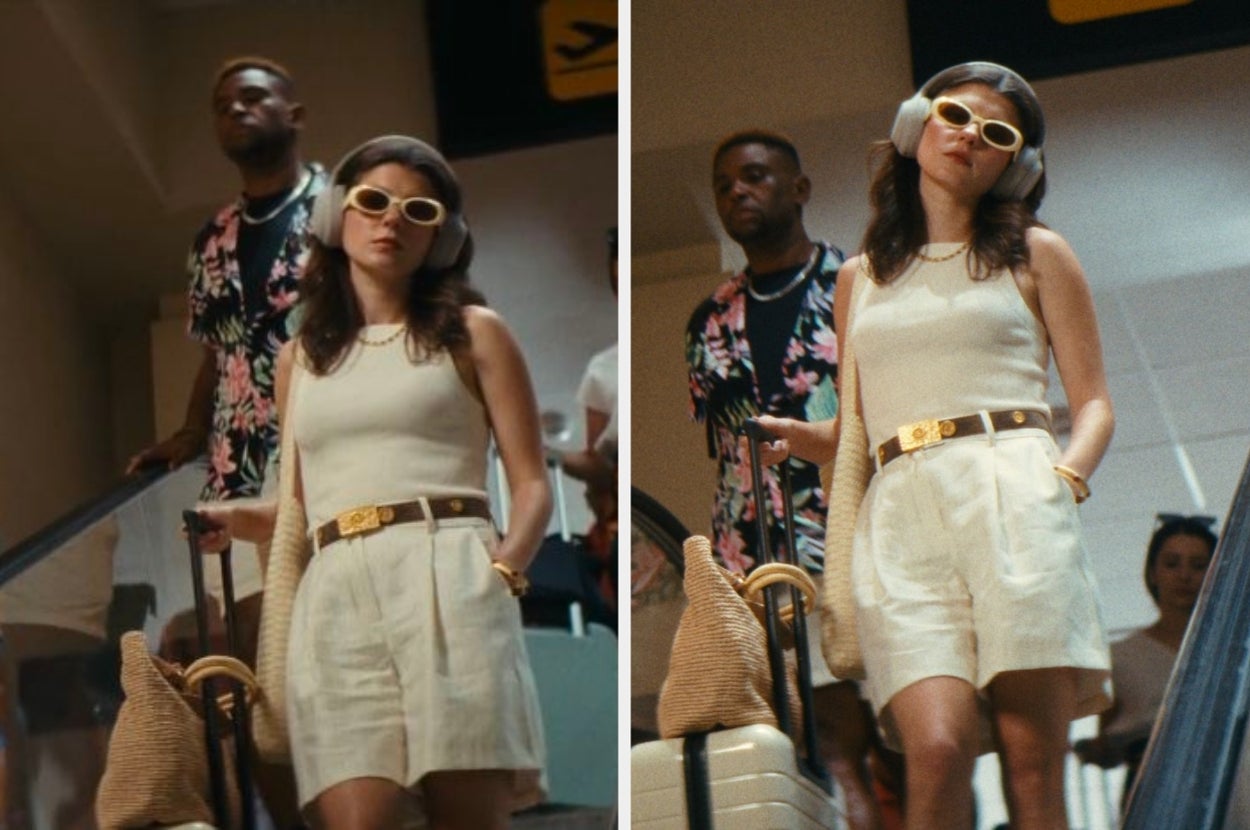Two people stand on an escalator. The woman wears stylish light clothing with a belt and sunglasses, holding a woven bag